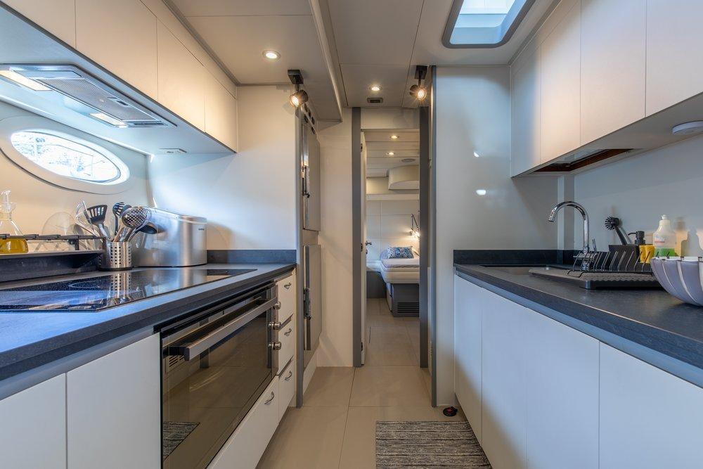 Modern kitchen interior on 2005 Aquamarine Albadra 600 yacht, featuring sleek countertops and appliances.