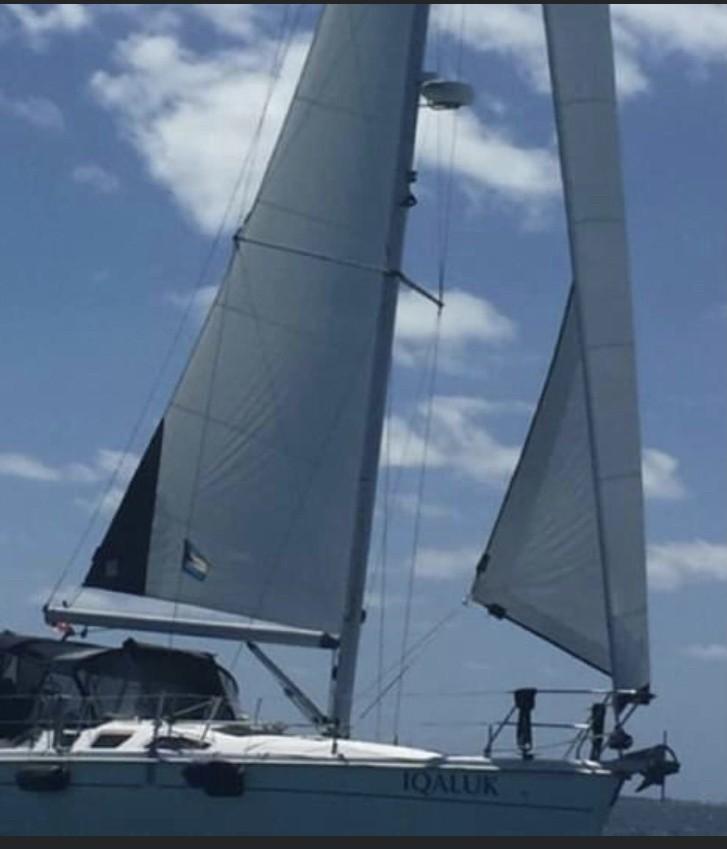 2004 Hunter 386 sailboat with full sails against a clear blue sky.