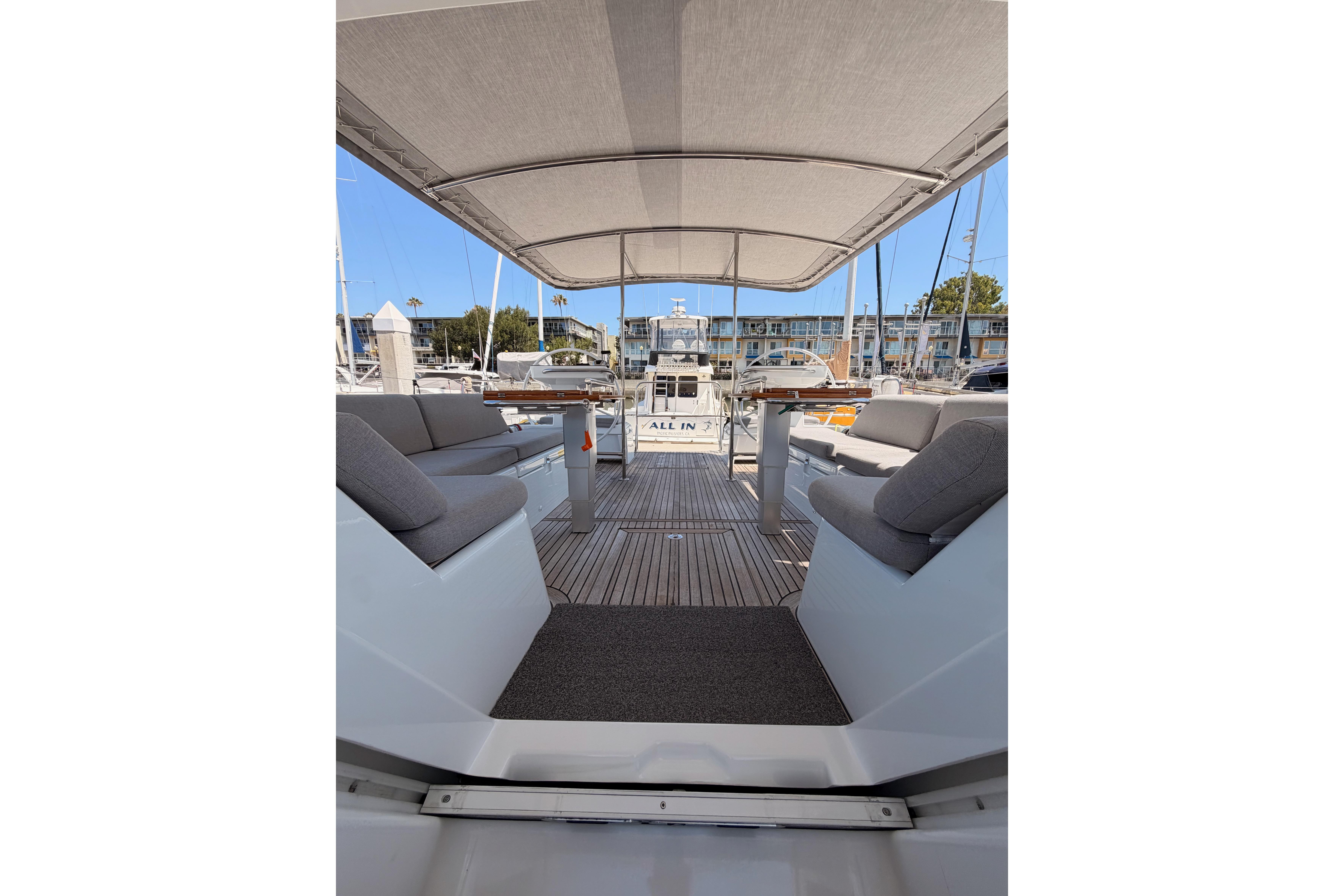 Spacious deck of 2022 Beneteau Oceanis Yacht 54 with comfortable seating and canopy.