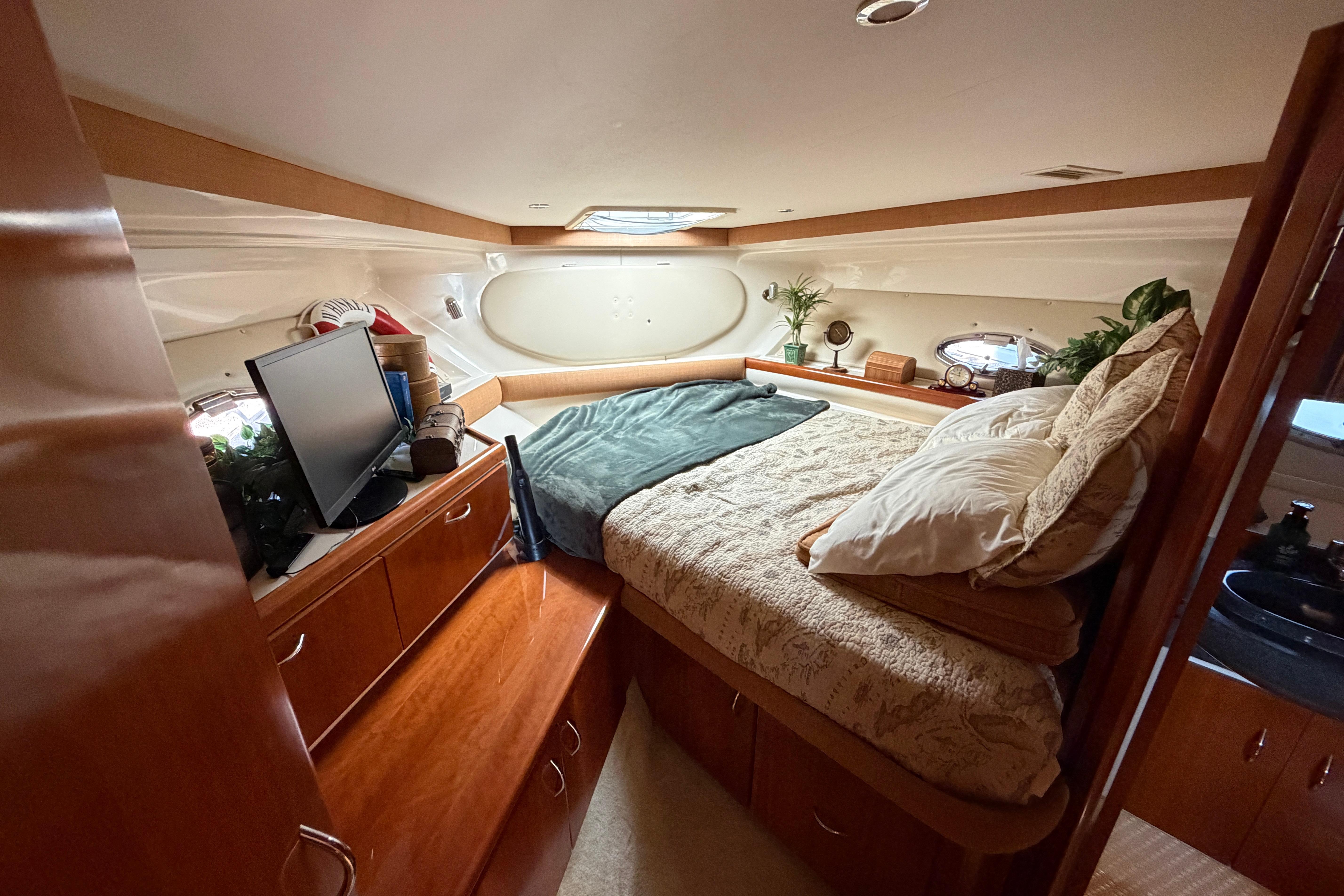 Cozy interior cabin of 2003 Carver 350 Mariner yacht with bed and wooden cabinetry.