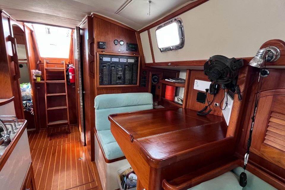 Interior of 2002 Pacific Seacraft 40 sailboat with wooden cabinetry and navigation station.