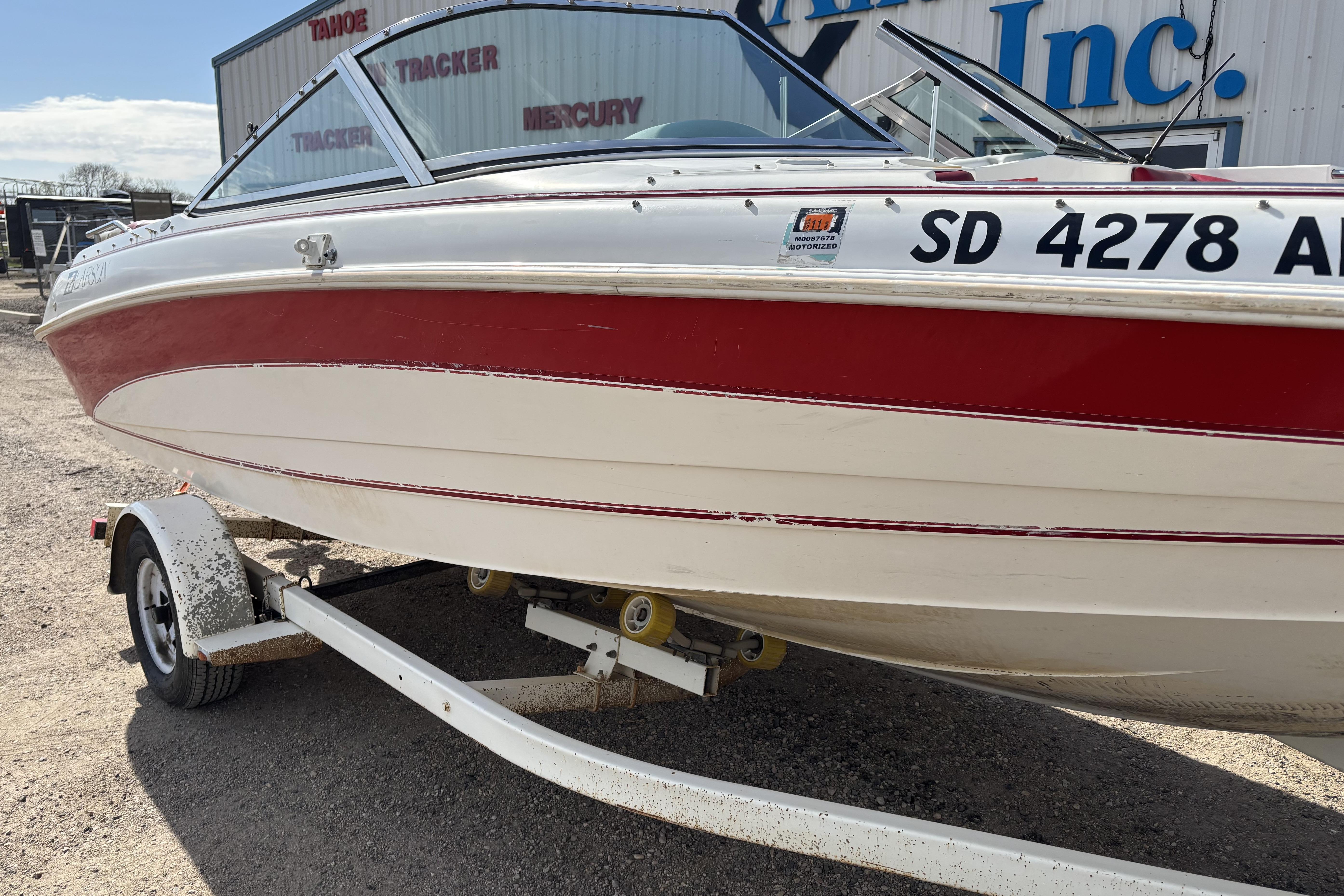 1993 Larson SEi 200 Cuddy I/O boat with red and white hull on trailer.