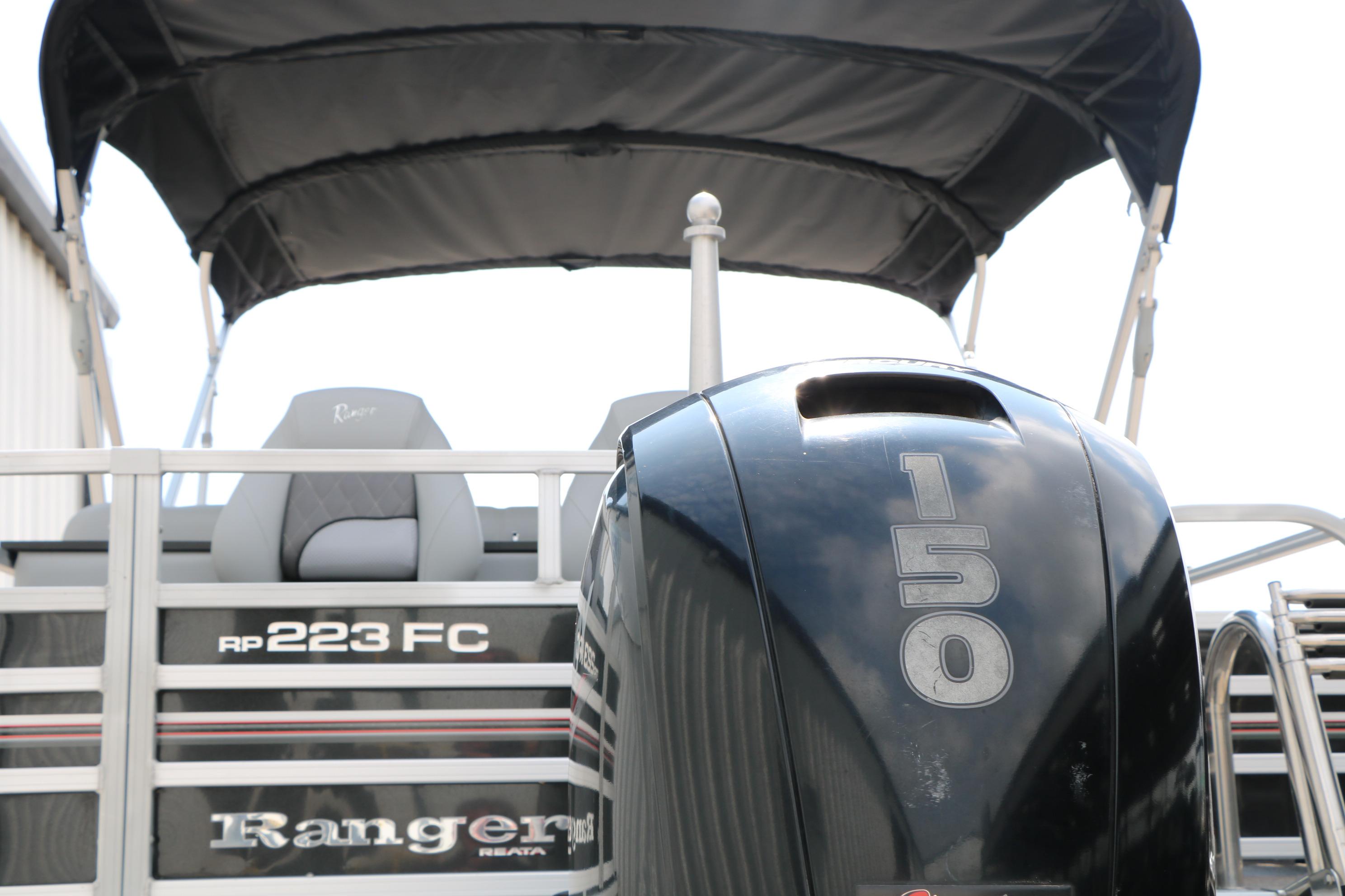 2021 Ranger 223FC boat with 150 horsepower engine, featuring canopy and seating.