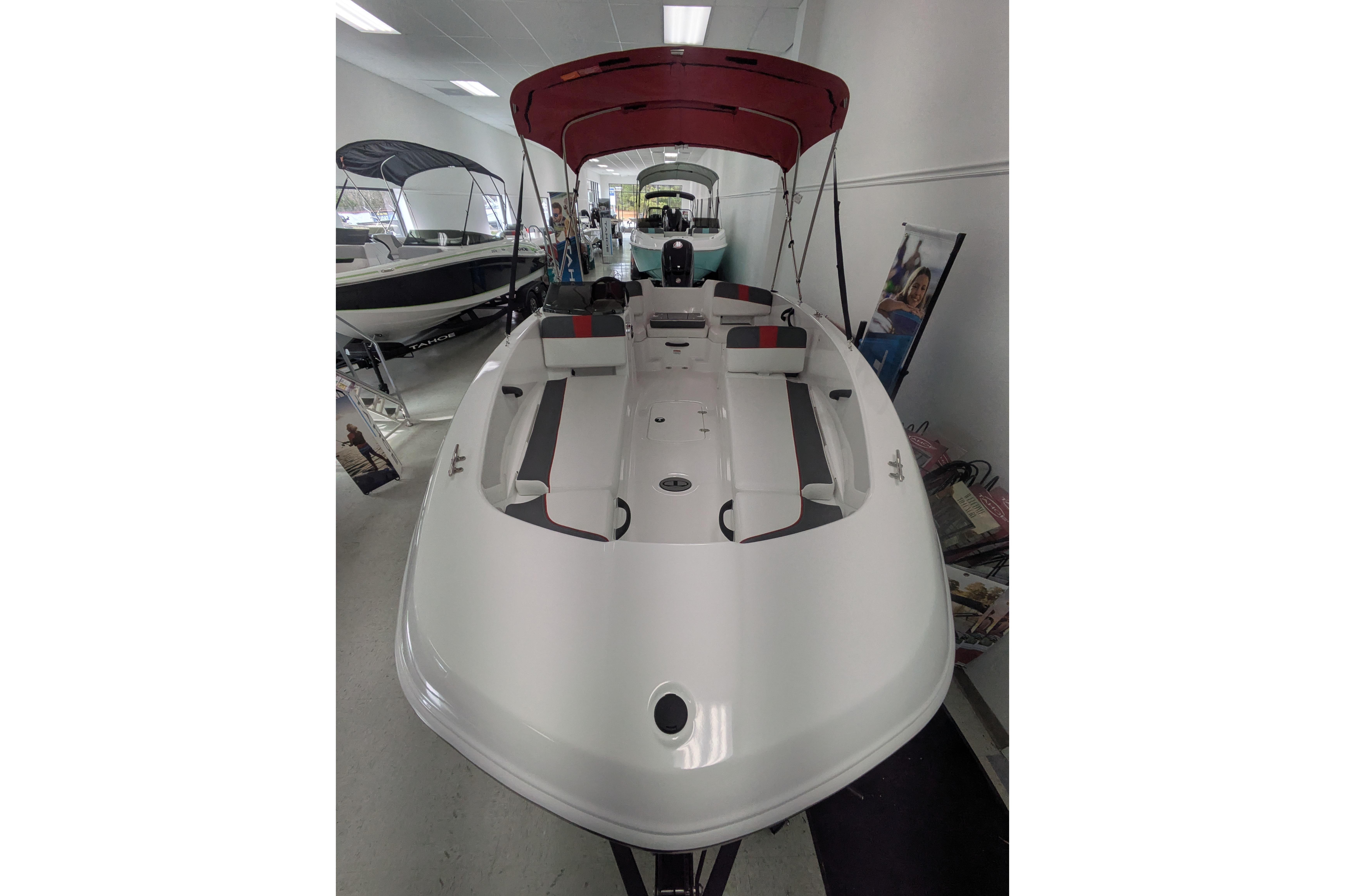 2026 Tahoe T18 boat with red canopy displayed in showroom.