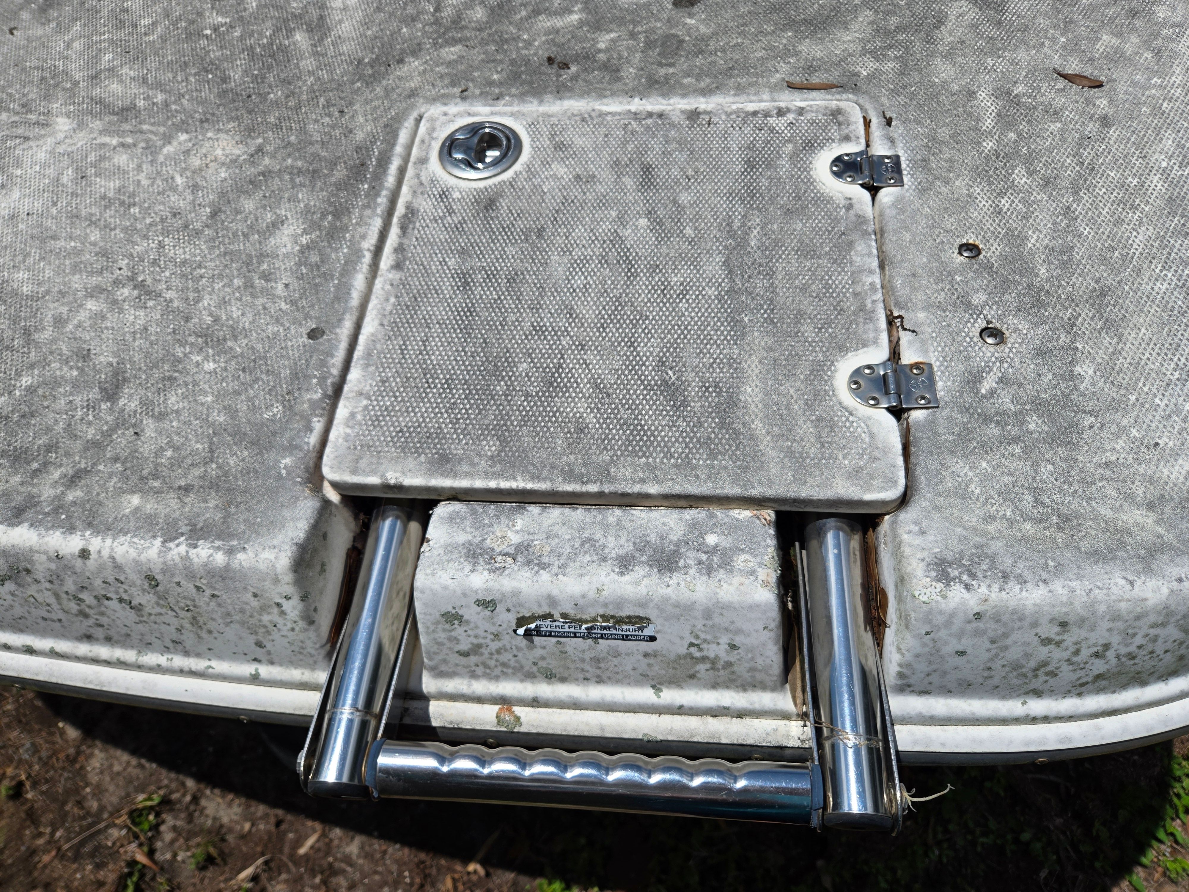 A swim platform with a retractable ladder and a small access hatch.