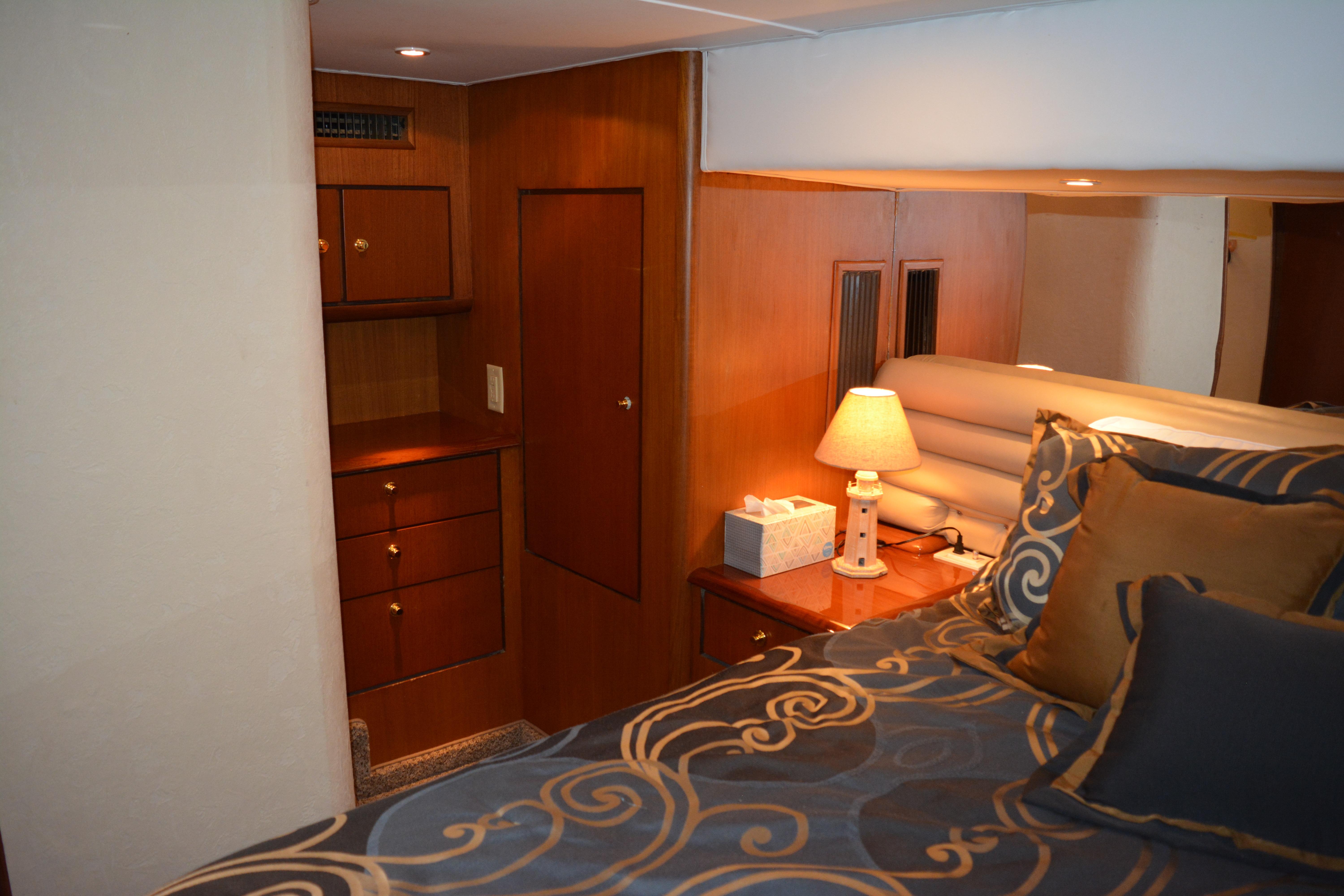 Luxurious cabin interior of 2001 Ocean 56 Super Sport yacht with elegant bedding and warm lighting.