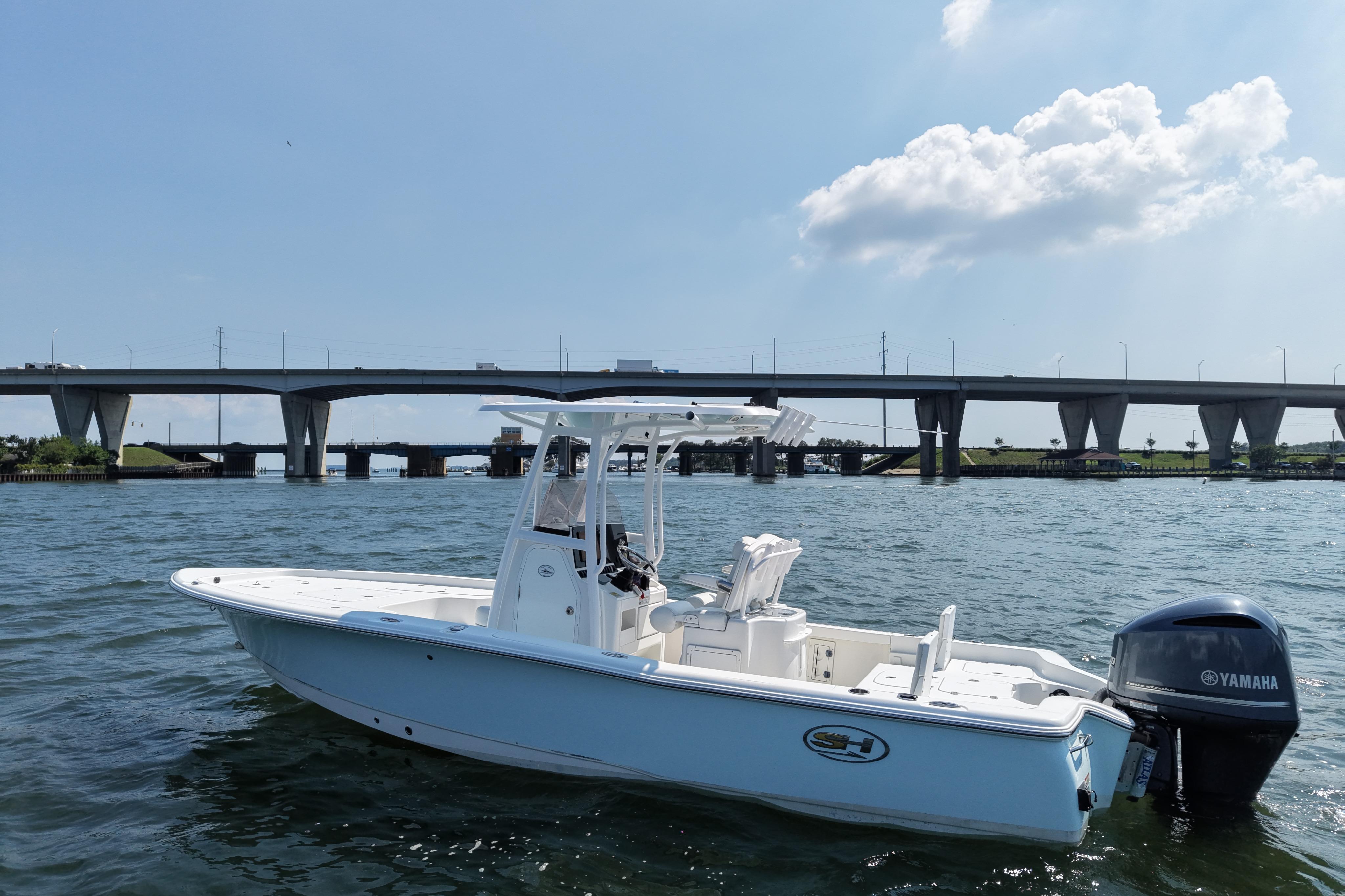 2017 Sea Hunt BX 25 BR boat on water near a bridge under a clear sky.