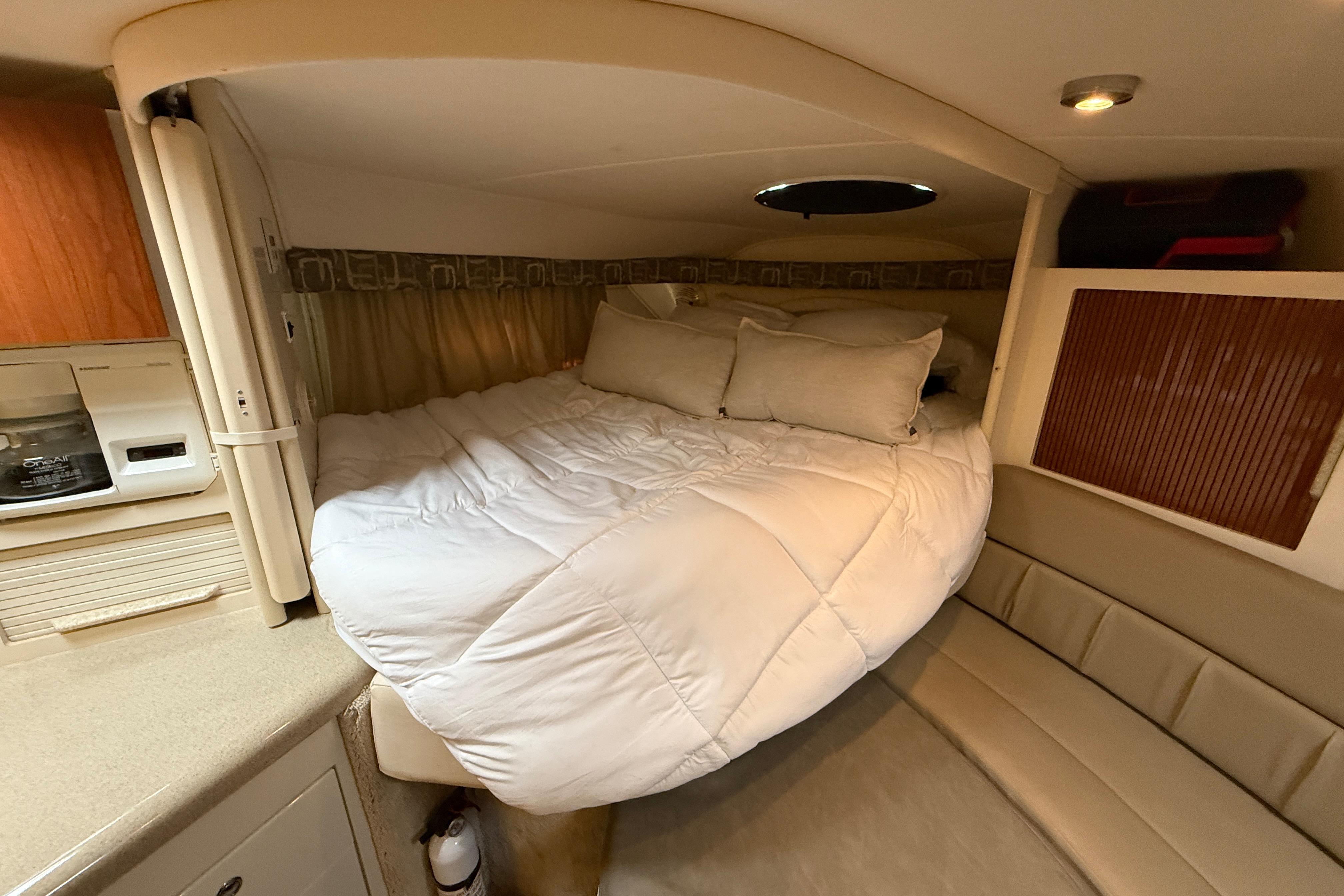 Cozy cabin interior of 2000 Monterey 322 Cruiser with bed and seating area.