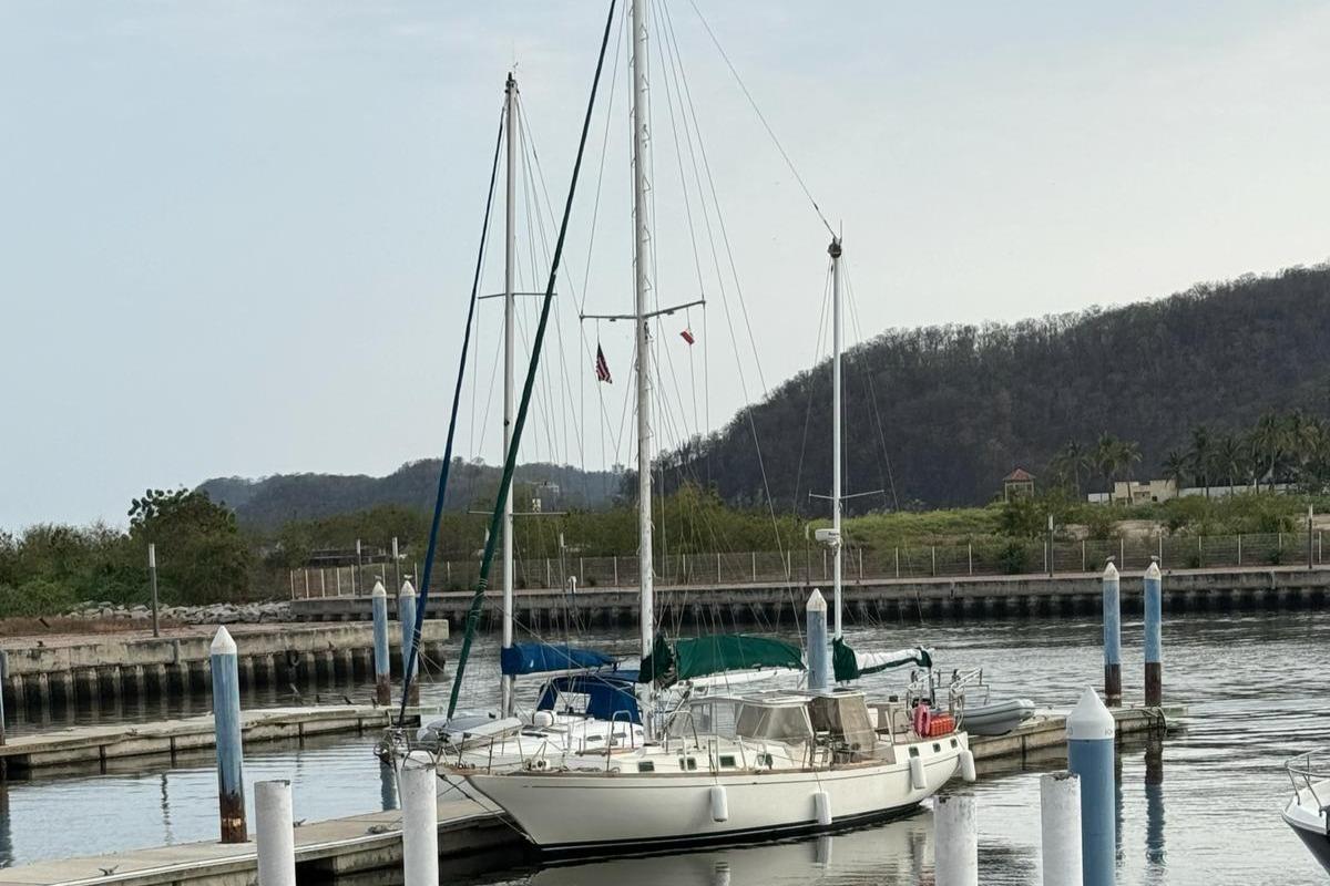 Sailboat docked in marina, Herreshoff 50, 1978 model, with scenic hillside background.