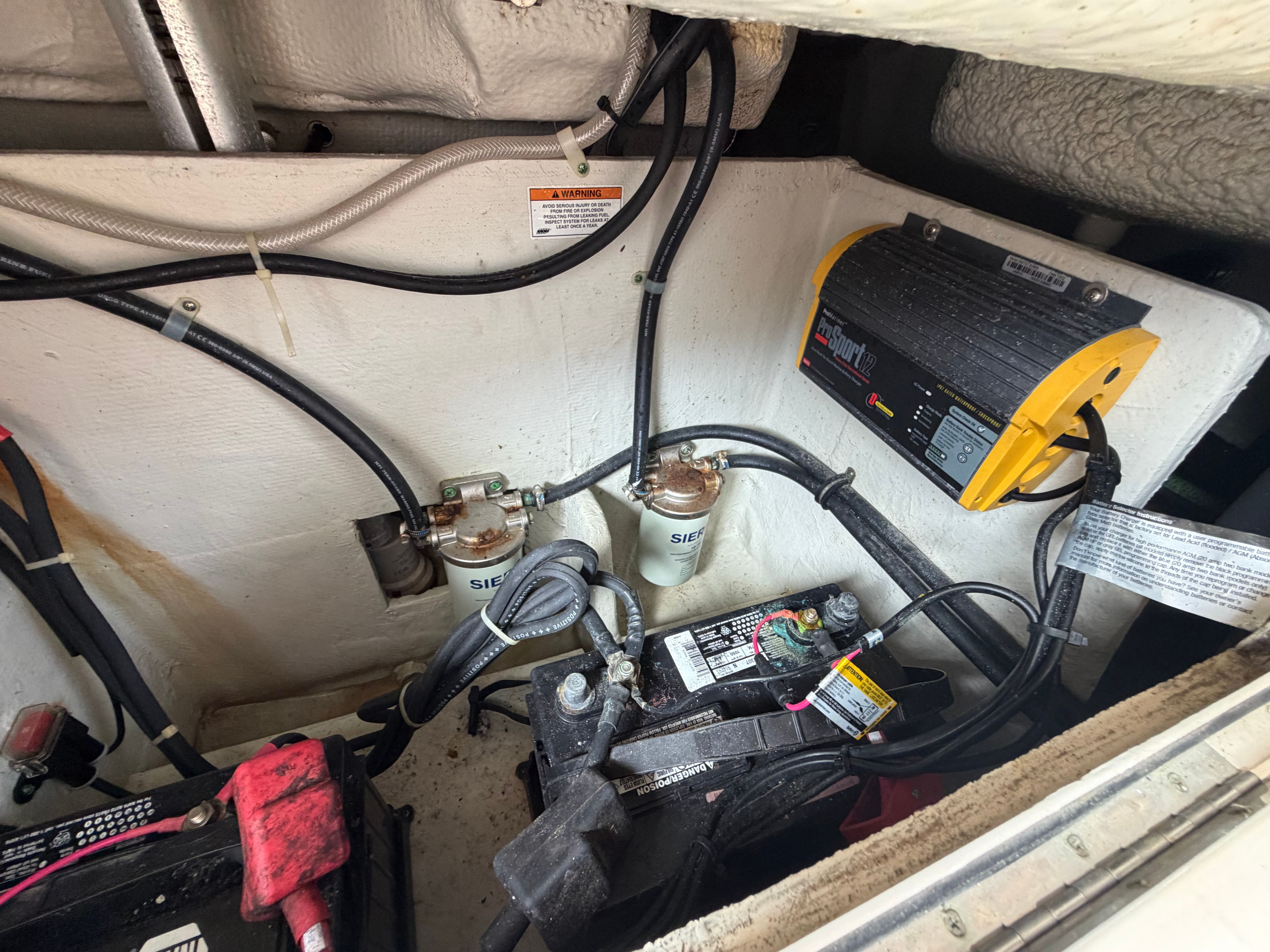 View of a boat's engine compartment with batteries and wiring.