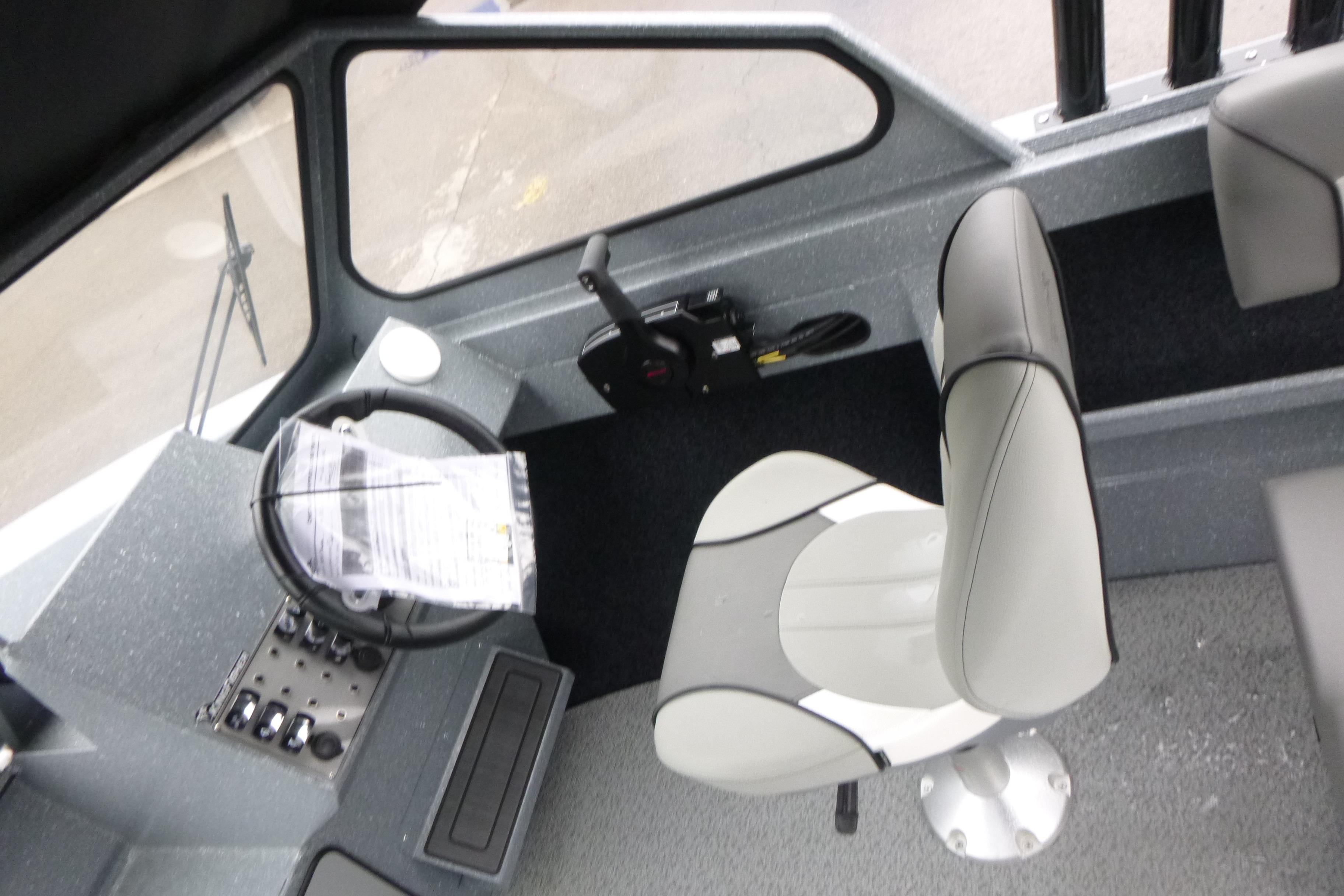Interior of 2026 KingFisher 2025 Escape boat, featuring steering wheel and captain's chair.