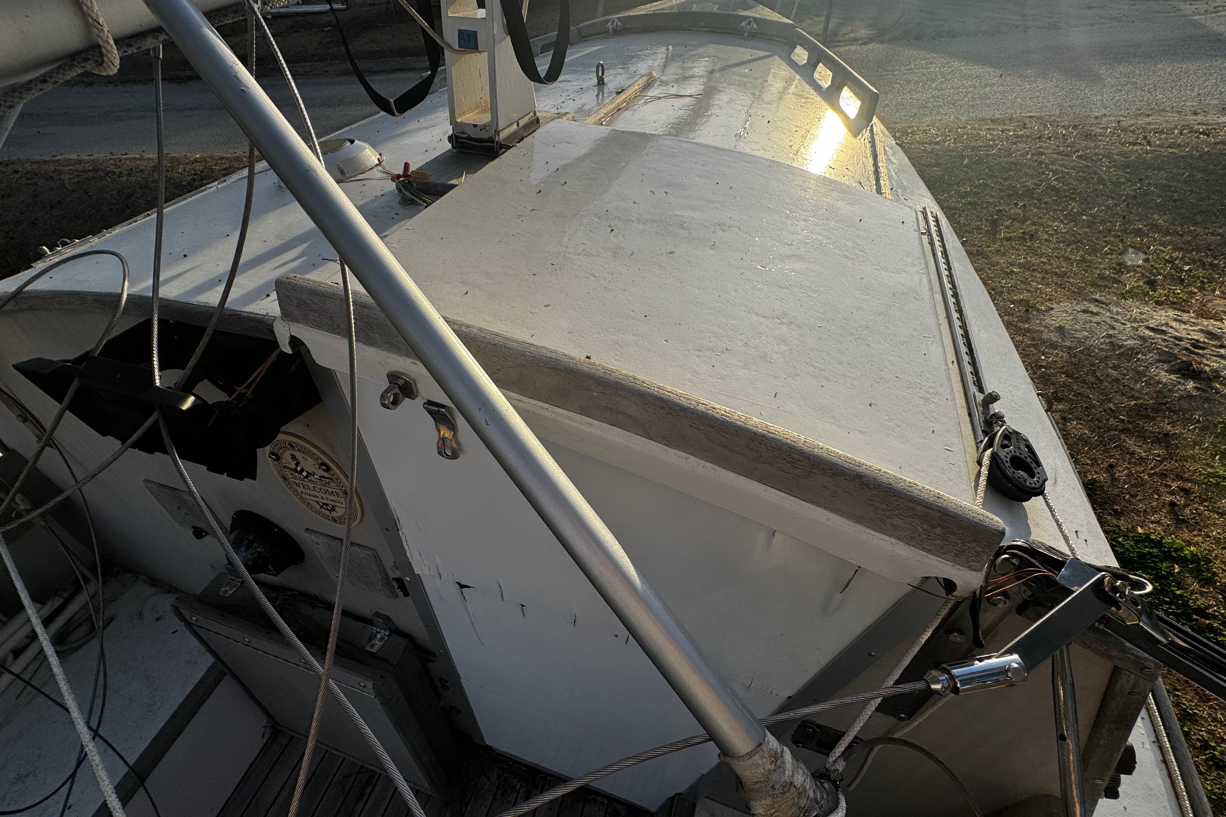 1976 Custom Wooden Sloop deck with rigging and sunlight reflection.