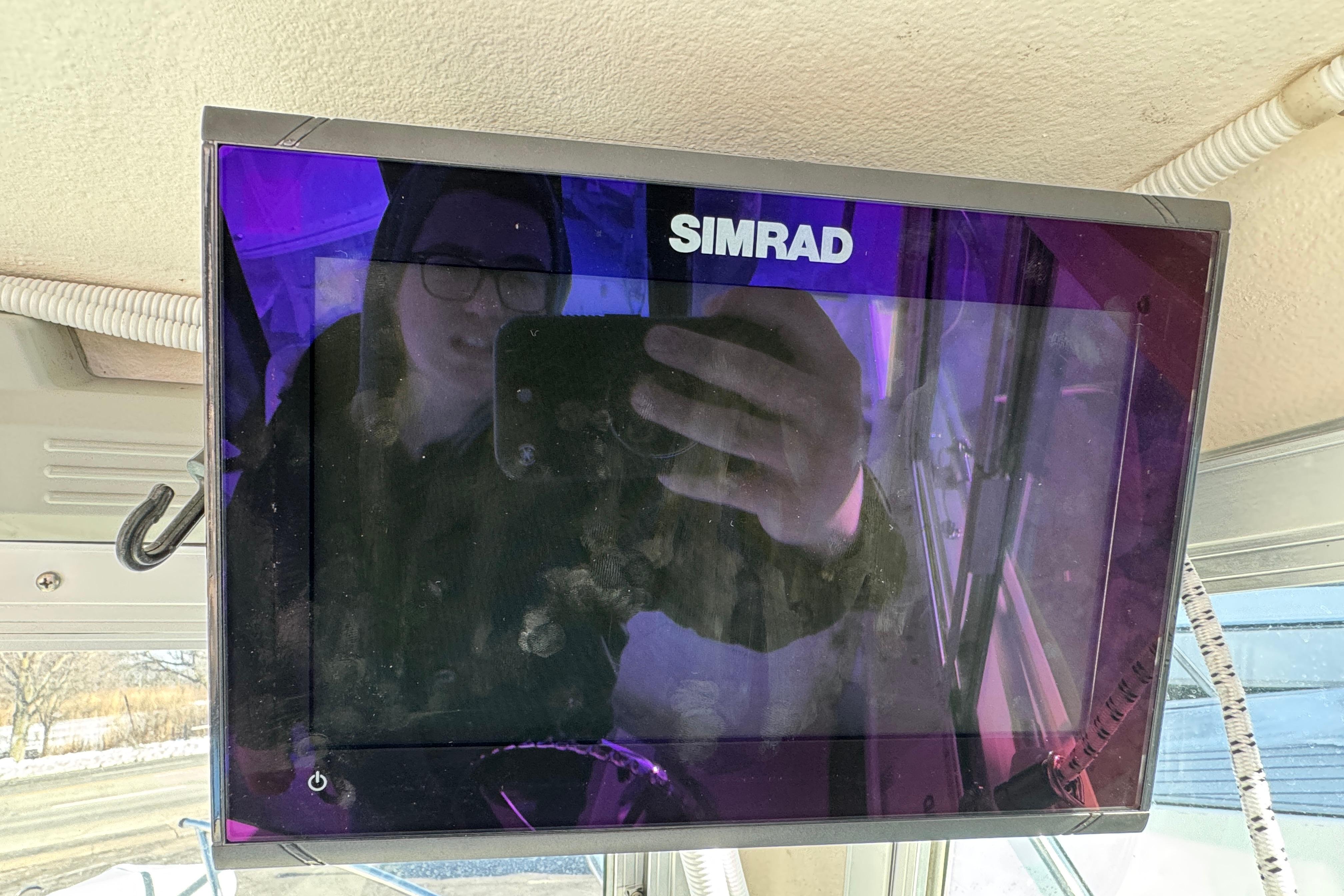 Simrad display on 2008 Steiger Craft 23 Miami boat, reflecting person taking photo.