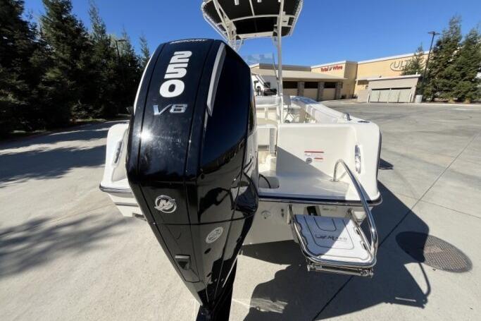 2025 Mako 214 Center Console boat with 250 V8 engine, parked outdoors.