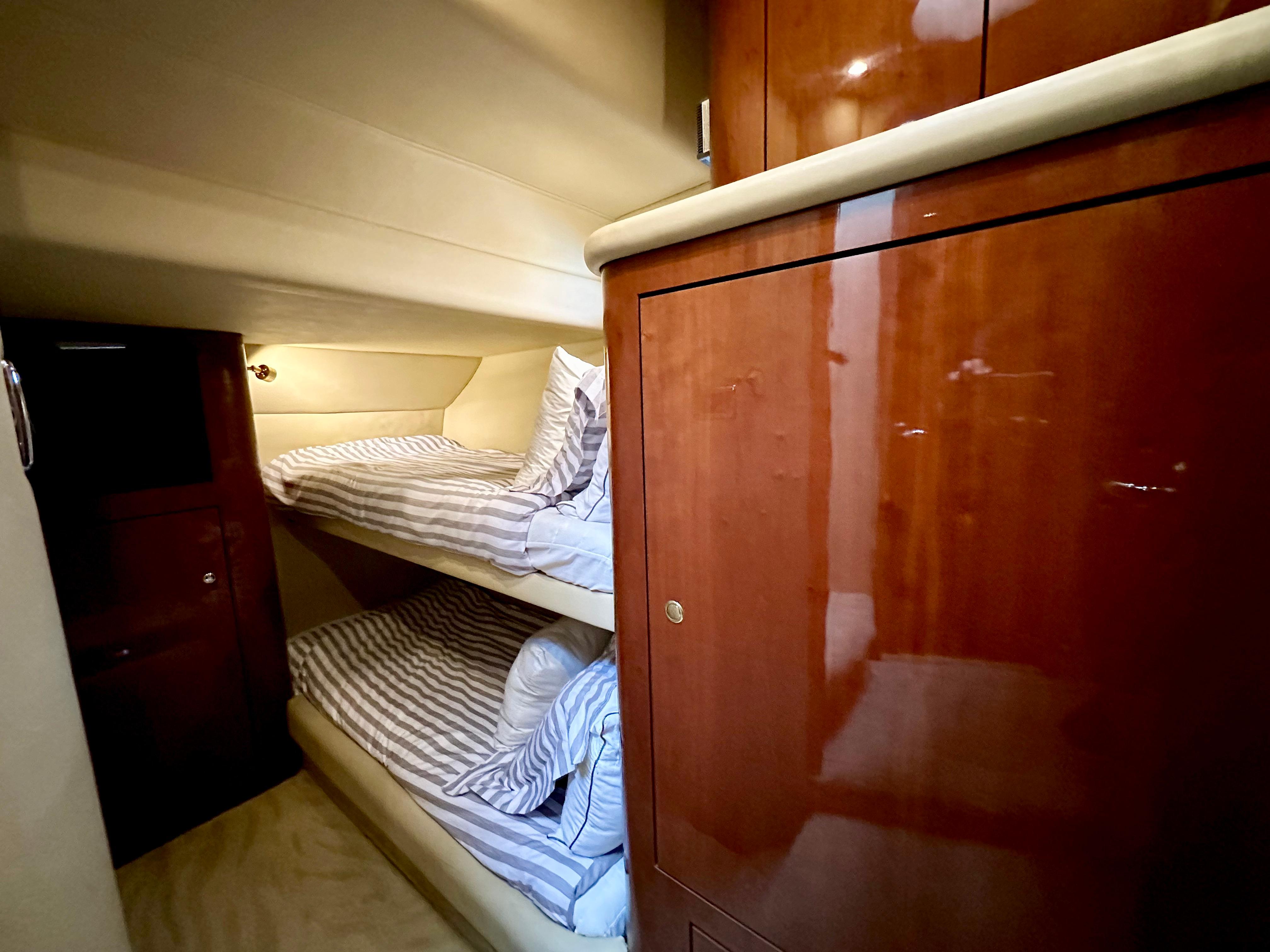 2002 Sea Ray 560 Sedan Bridge cabin with wooden cabinetry and bunk beds.