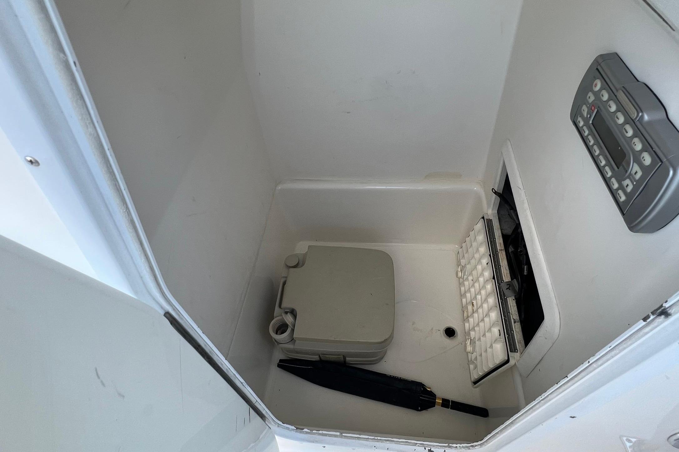Interior of a 2006 Edgewater 245CC boat compartment with storage items.