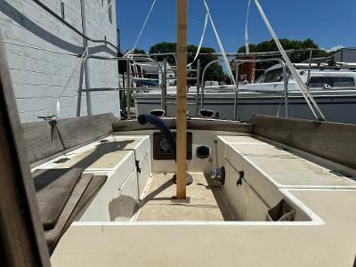 The cockpit of a 1985 Cape Dory 25D with a wooden mast and seating benches.