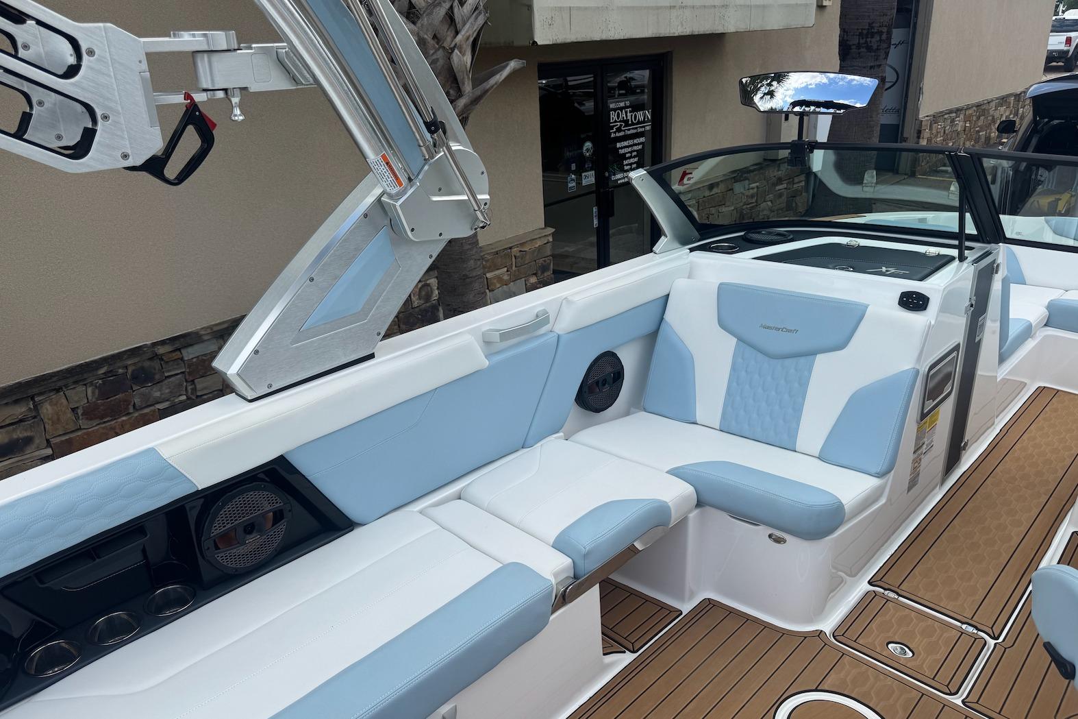 2023 MasterCraft XT24 boat interior with blue and white seating and teak flooring.