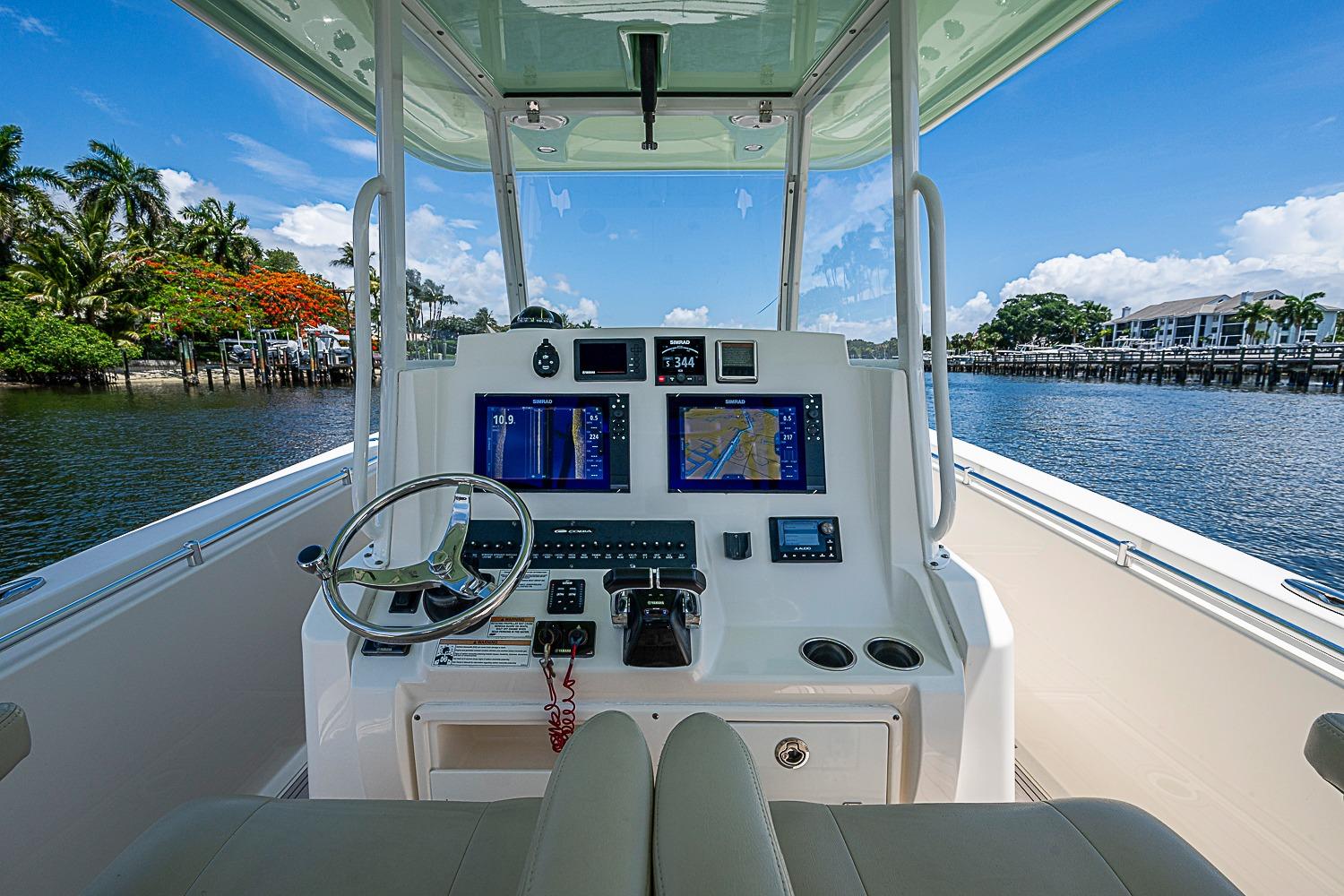 2019 Cobia 320 Center Console boat dashboard with navigation screens on a sunny day.