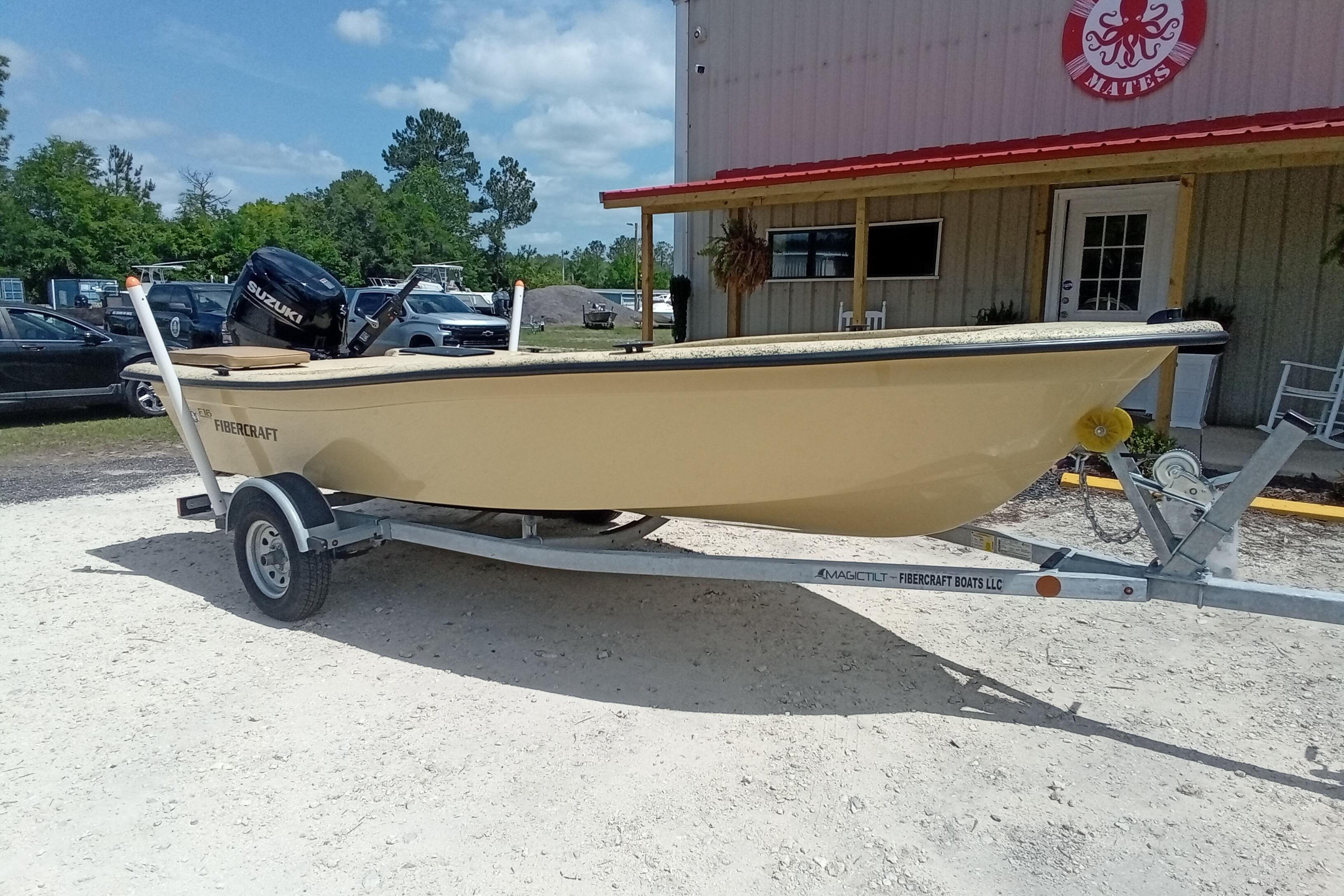 2025 Fibercraft F16 boat on trailer, parked outside a building on a sunny day.