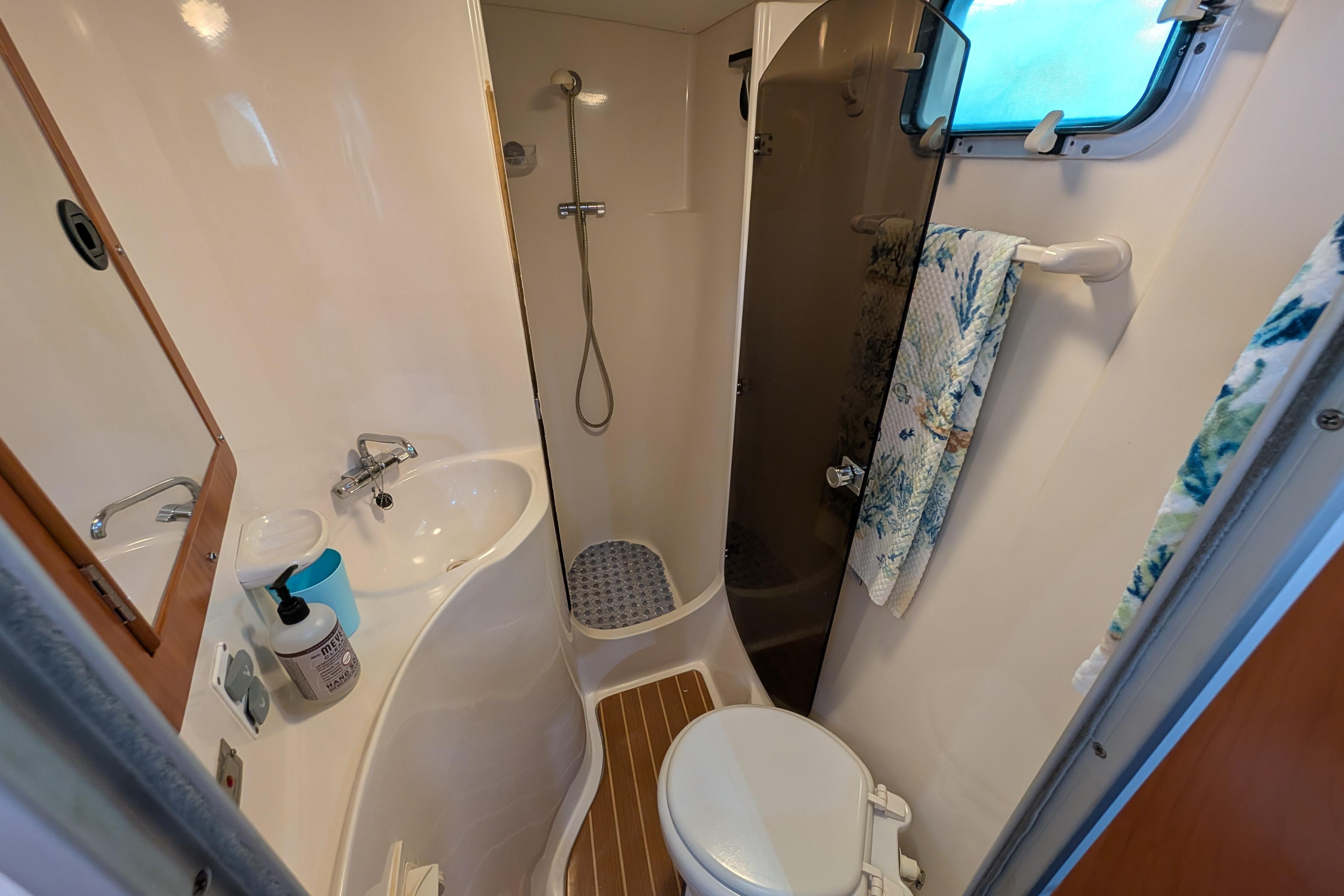Compact bathroom in a 2004 PDQ 34 Powercat, featuring a shower, sink, and toilet.