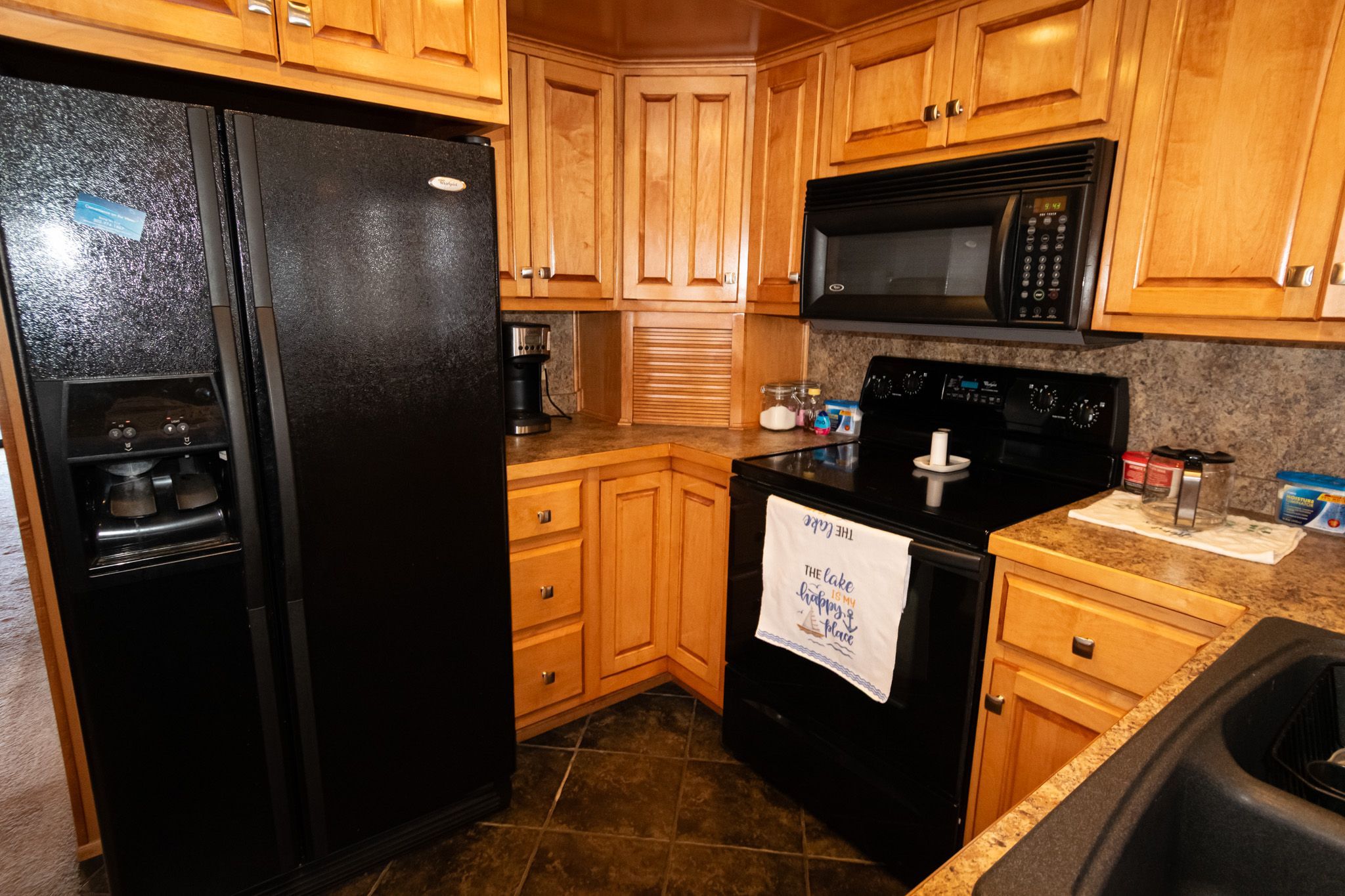Lakeview 16x70 houseboat kitchen, 2003 model, featuring black appliances.