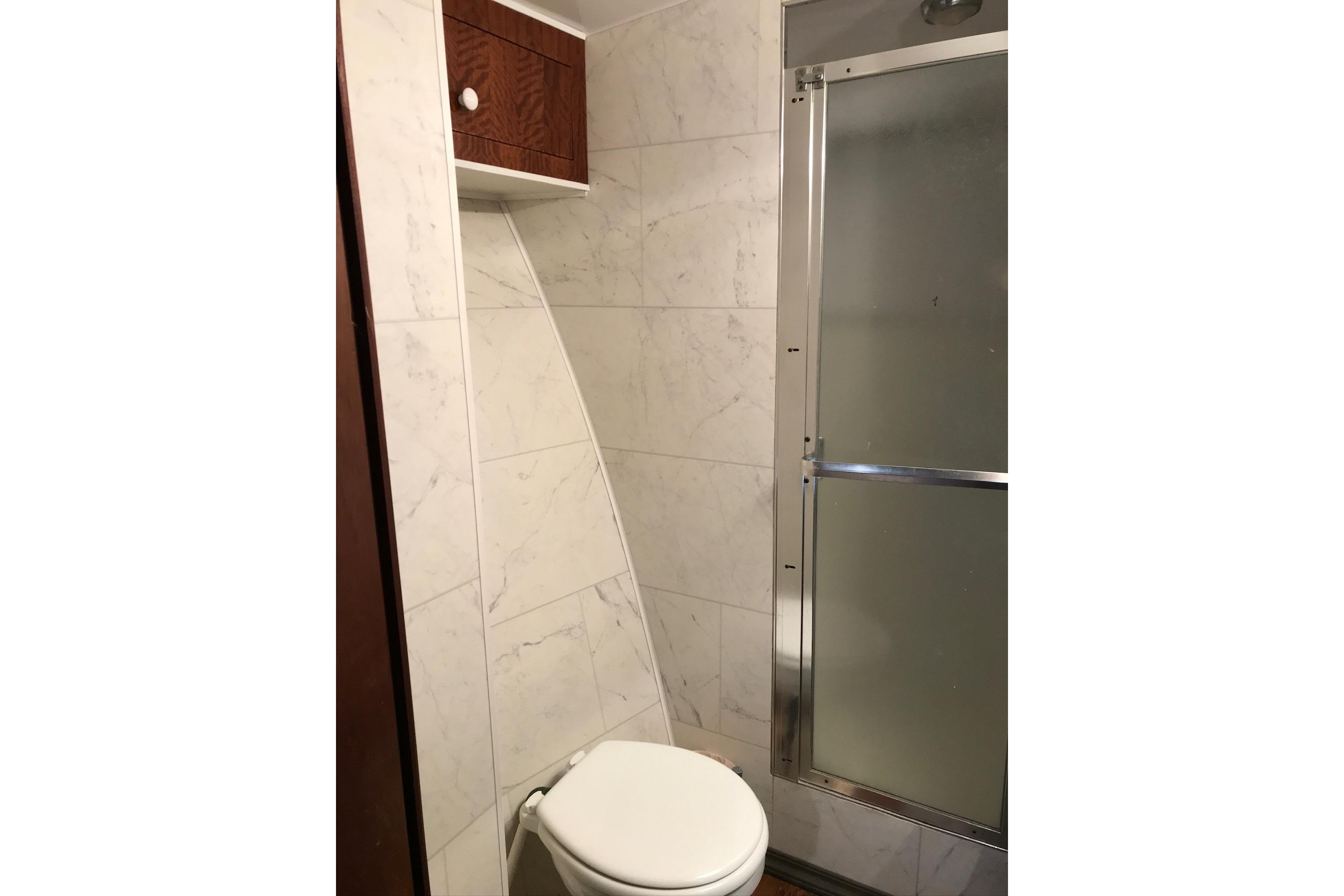 Bathroom interior of 1976 Hatteras 53 Convertible yacht with shower and toilet.
