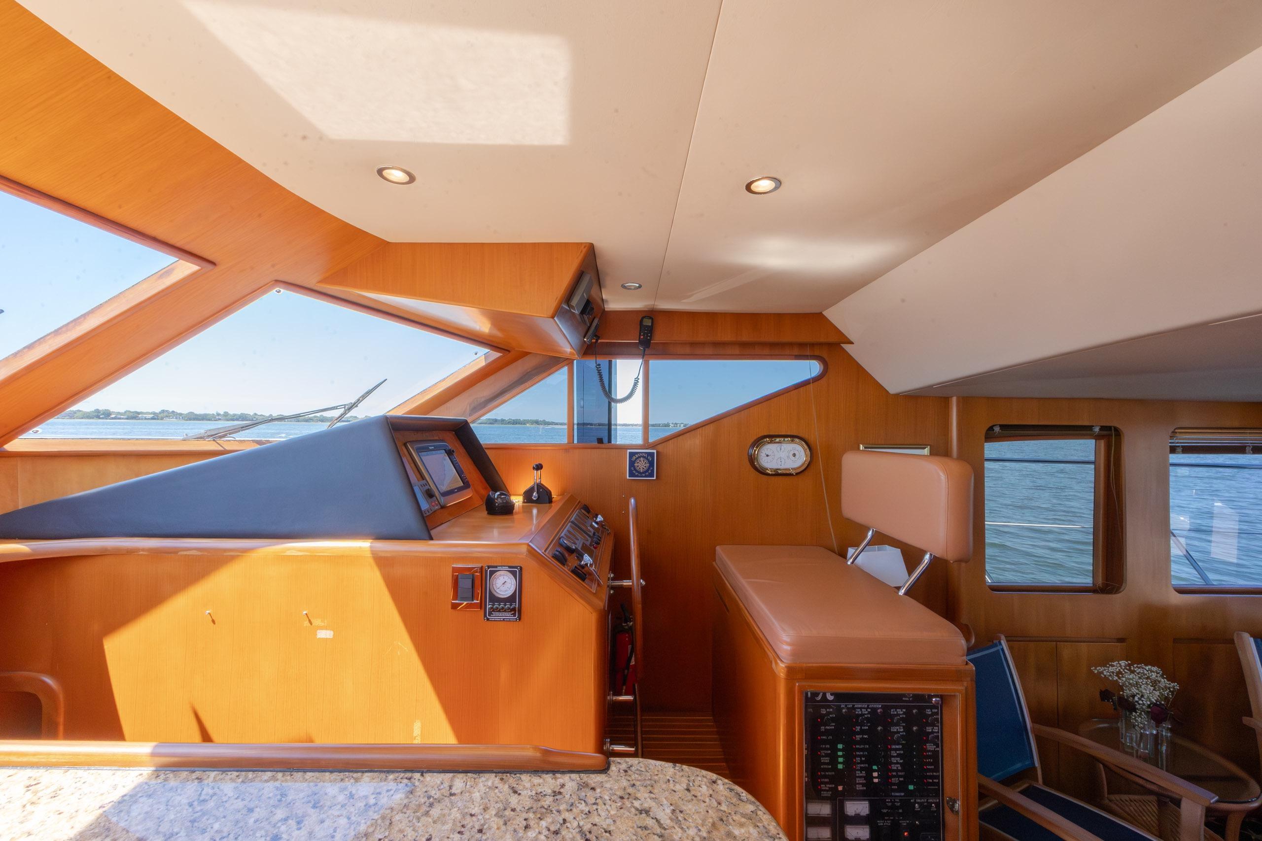 Interior view of 2005 Ocean Alexander 52 Sedan yacht helm with wood finish.