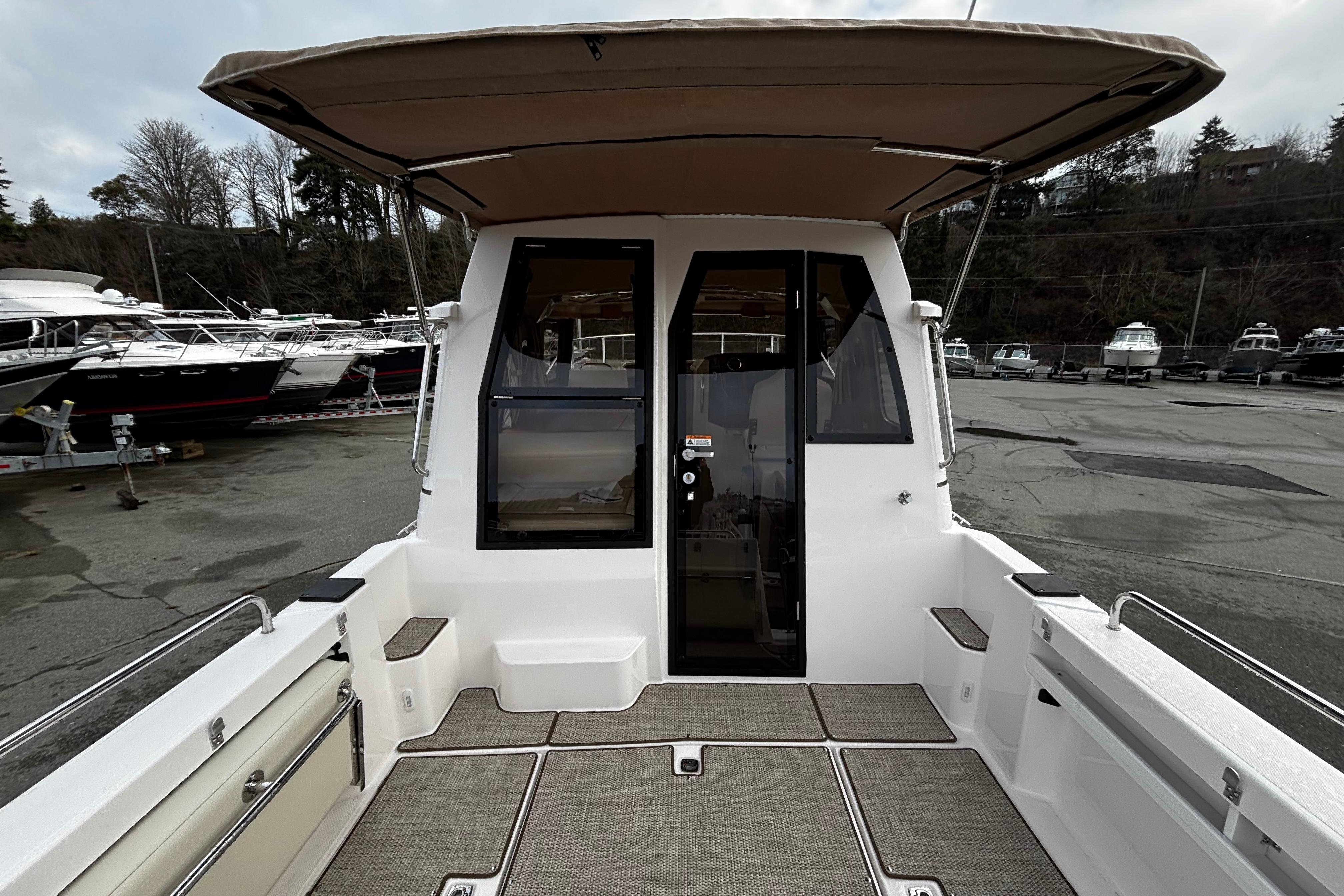 2026 Ranger Tugs R-25 with covered cockpit and glass windows at marina.