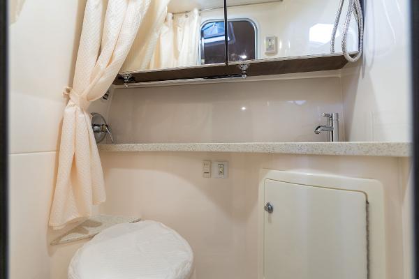 2016 Regal 28 Express boat bathroom with sink, mirror, and shower curtain.