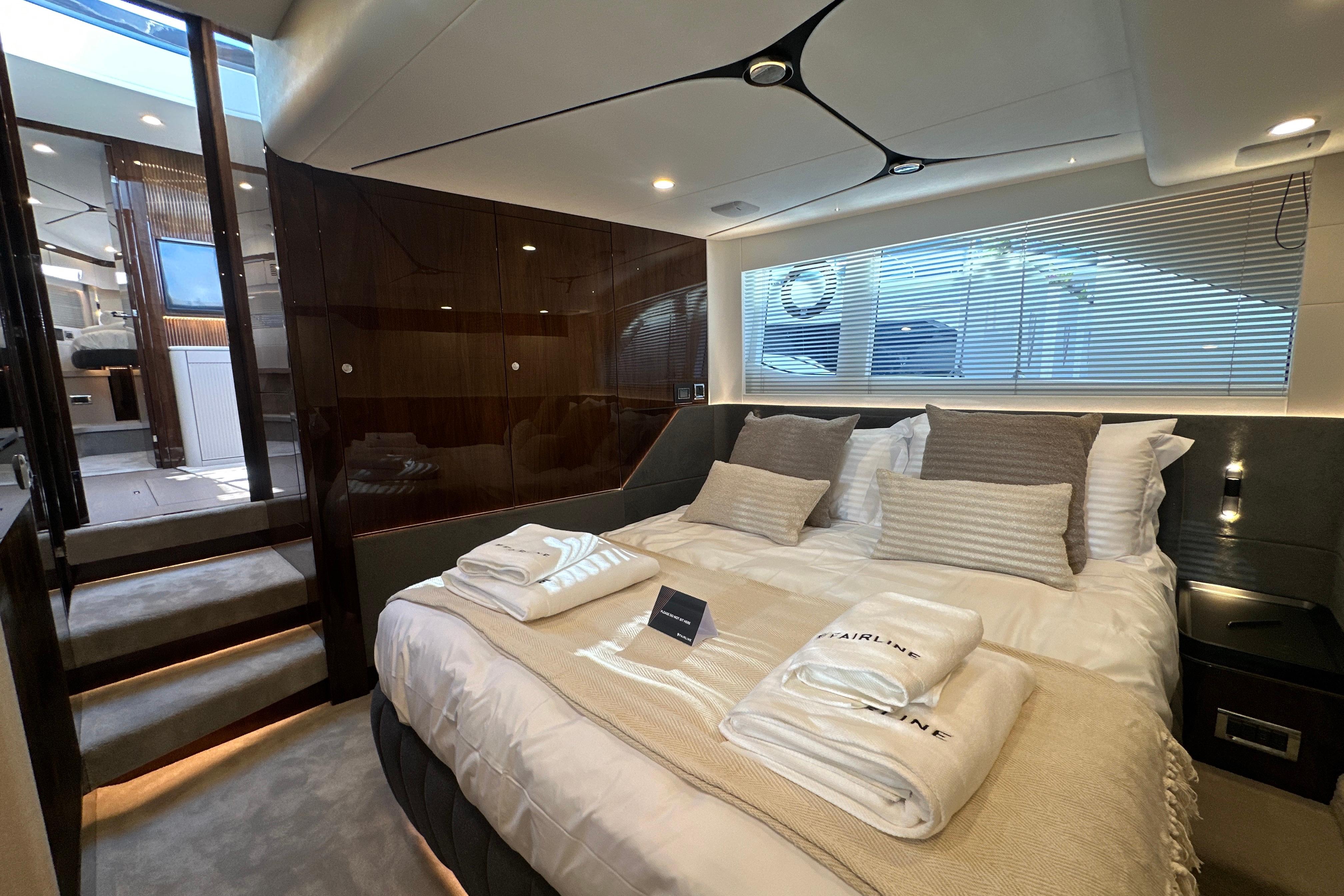 Luxurious bedroom interior of 2026 Fairline Targa 47 GT yacht with elegant bedding.