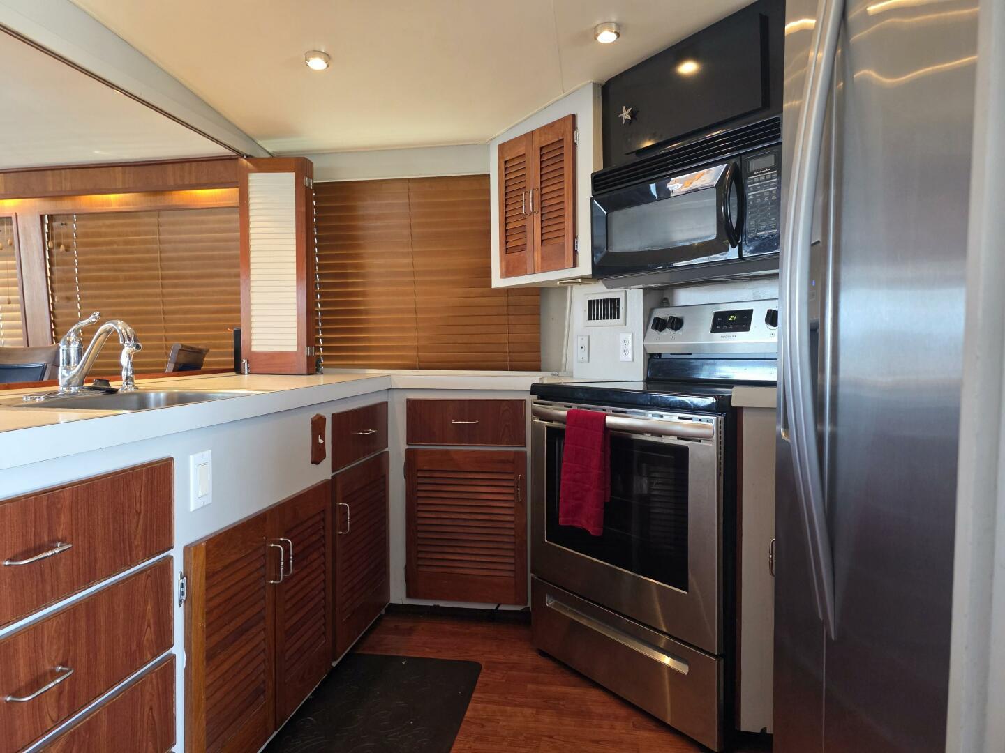 1976 Chris-Craft Roamer 60 yacht kitchen with modern appliances and wooden cabinetry.