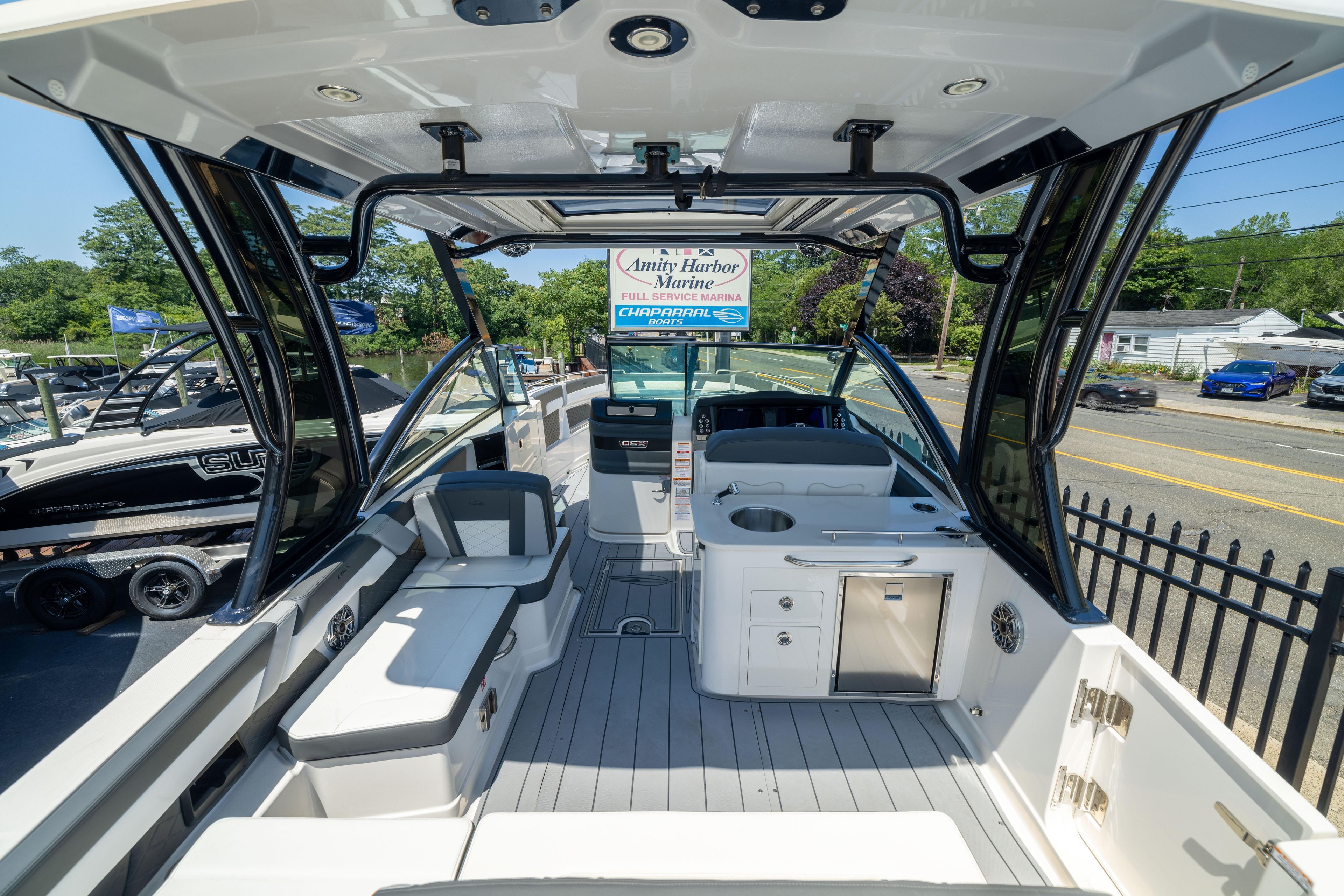 2026 Chaparral 310 OSX boat interior with seating and kitchenette, docked at marina.