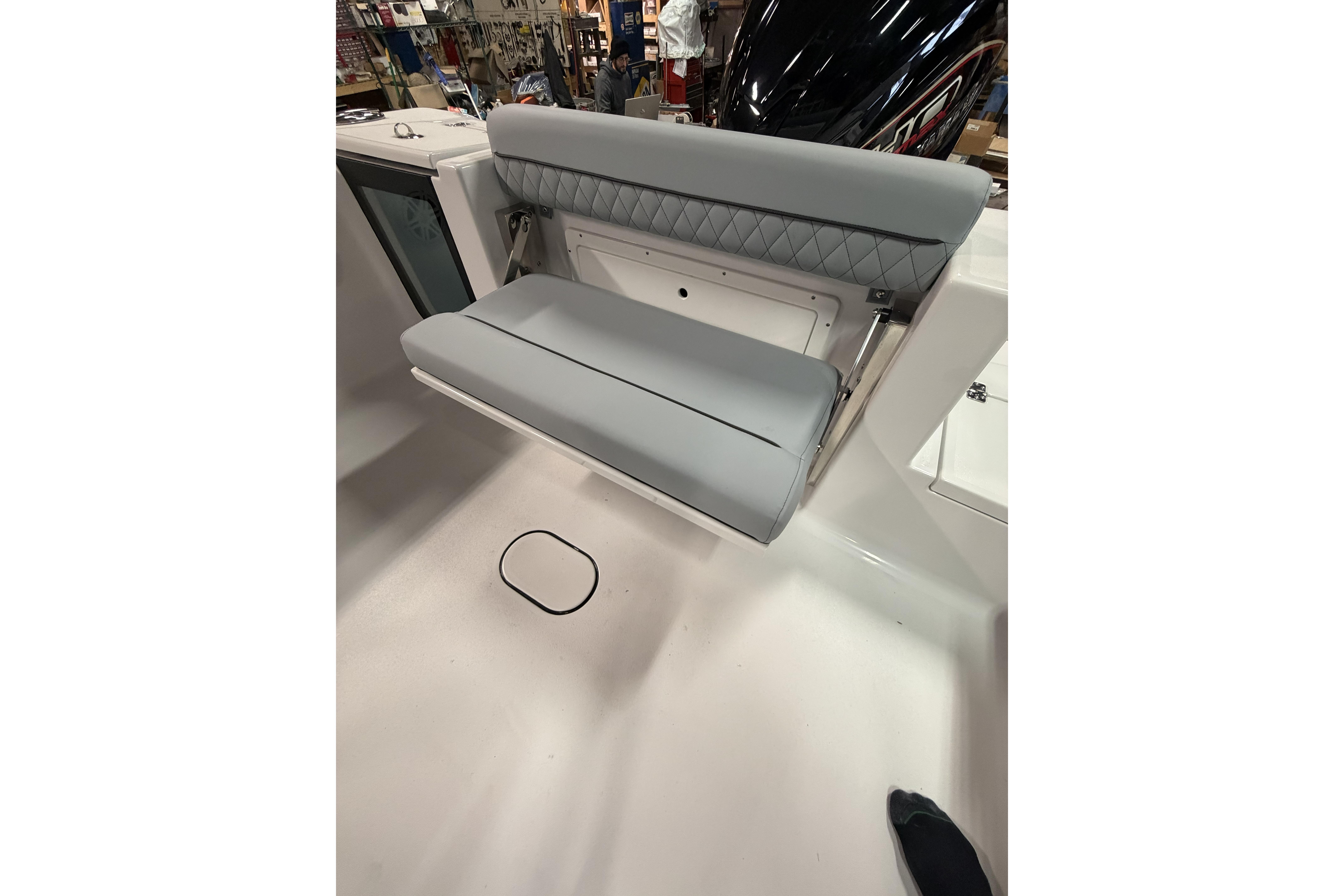 2026 Sportsman Open 232 Center Console boat with foldable gray seating.