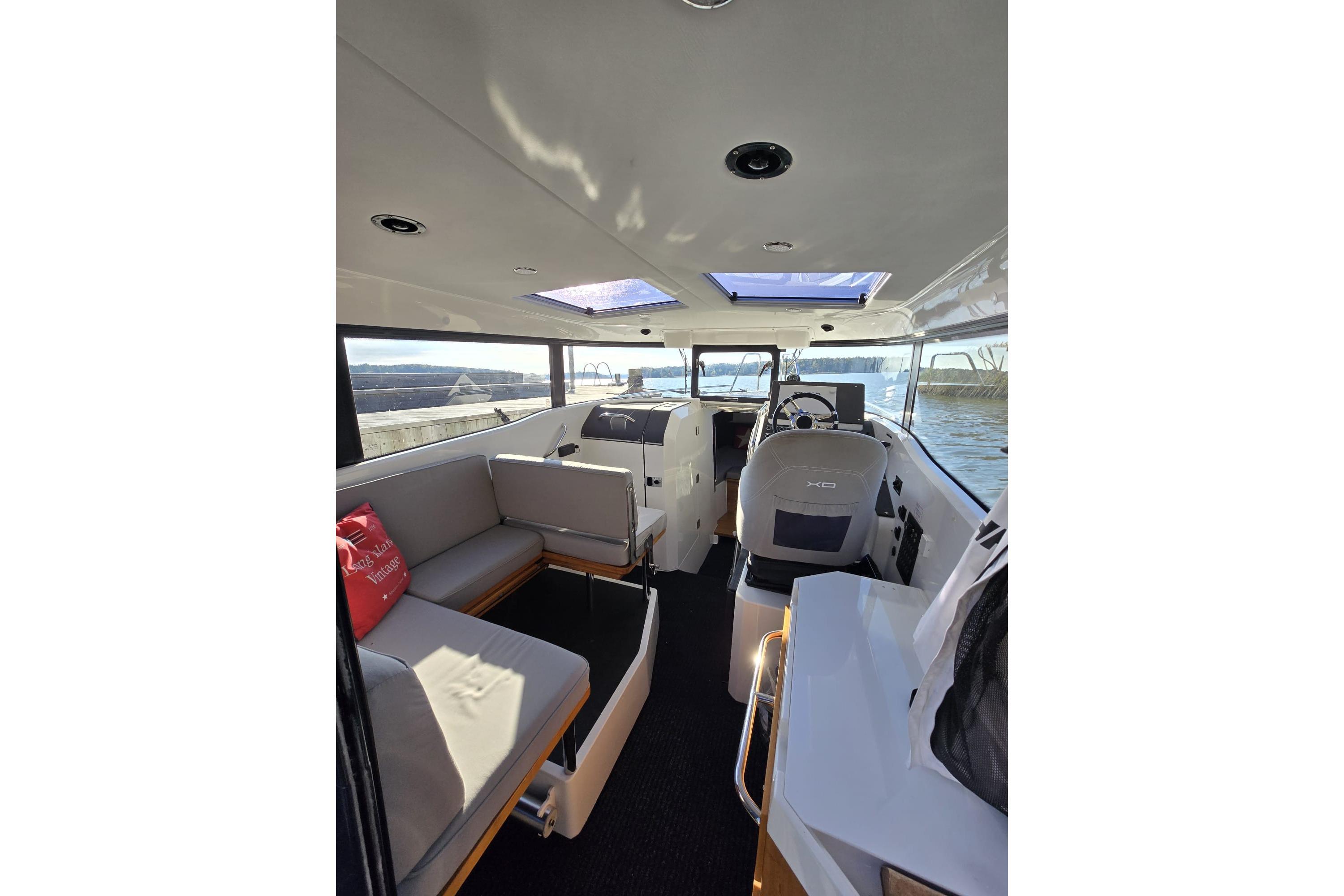 Interior of 2016 XO Boats 270 RS, featuring seating and helm, with scenic water view.