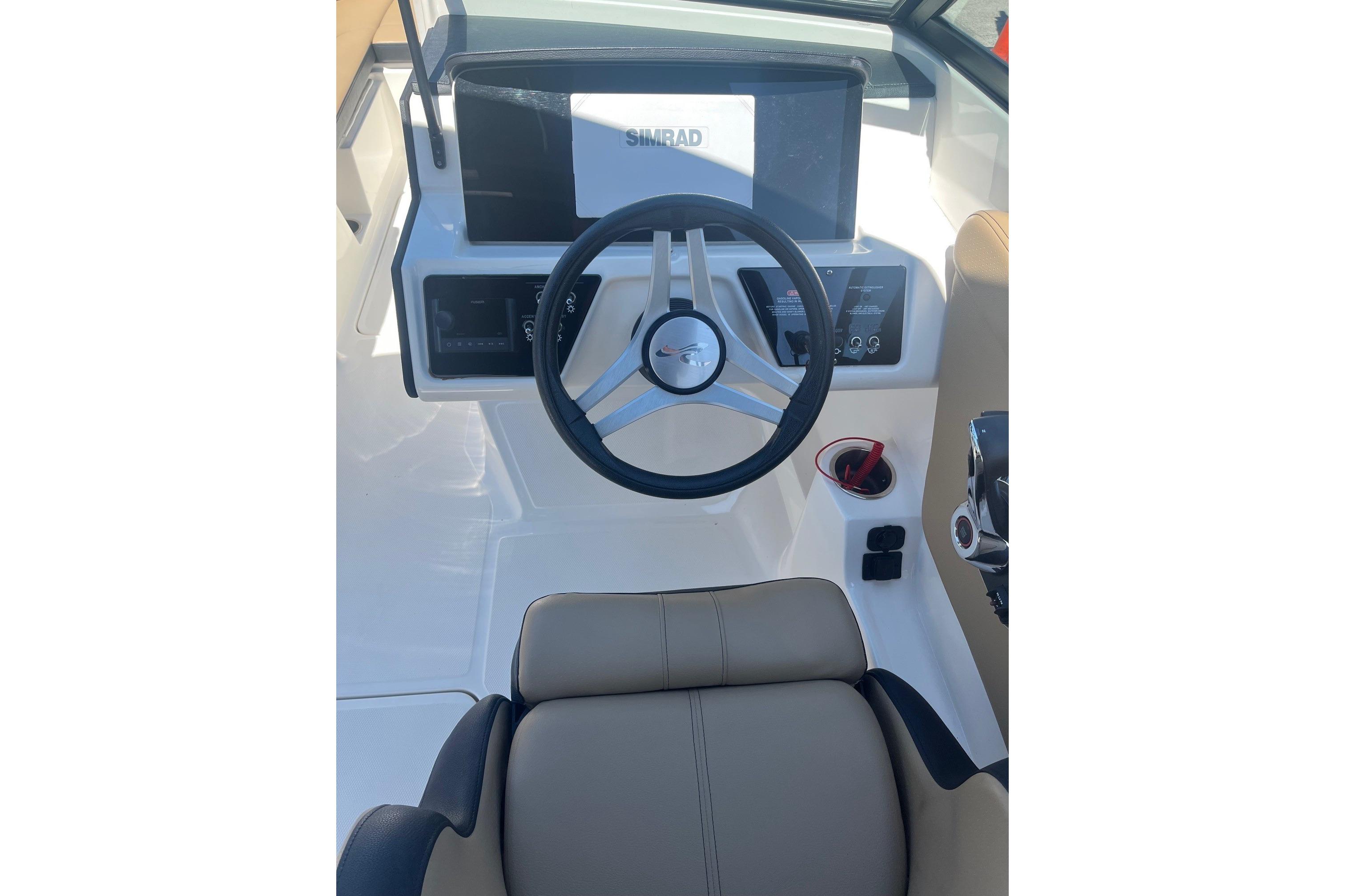 2024 Sea Ray SPX 230 boat cockpit with steering wheel and dashboard controls.
