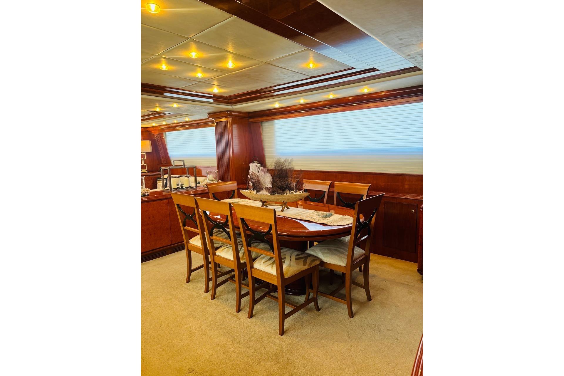 Luxurious dining area on 2000 Falcon 100 yacht with elegant wooden furnishings.