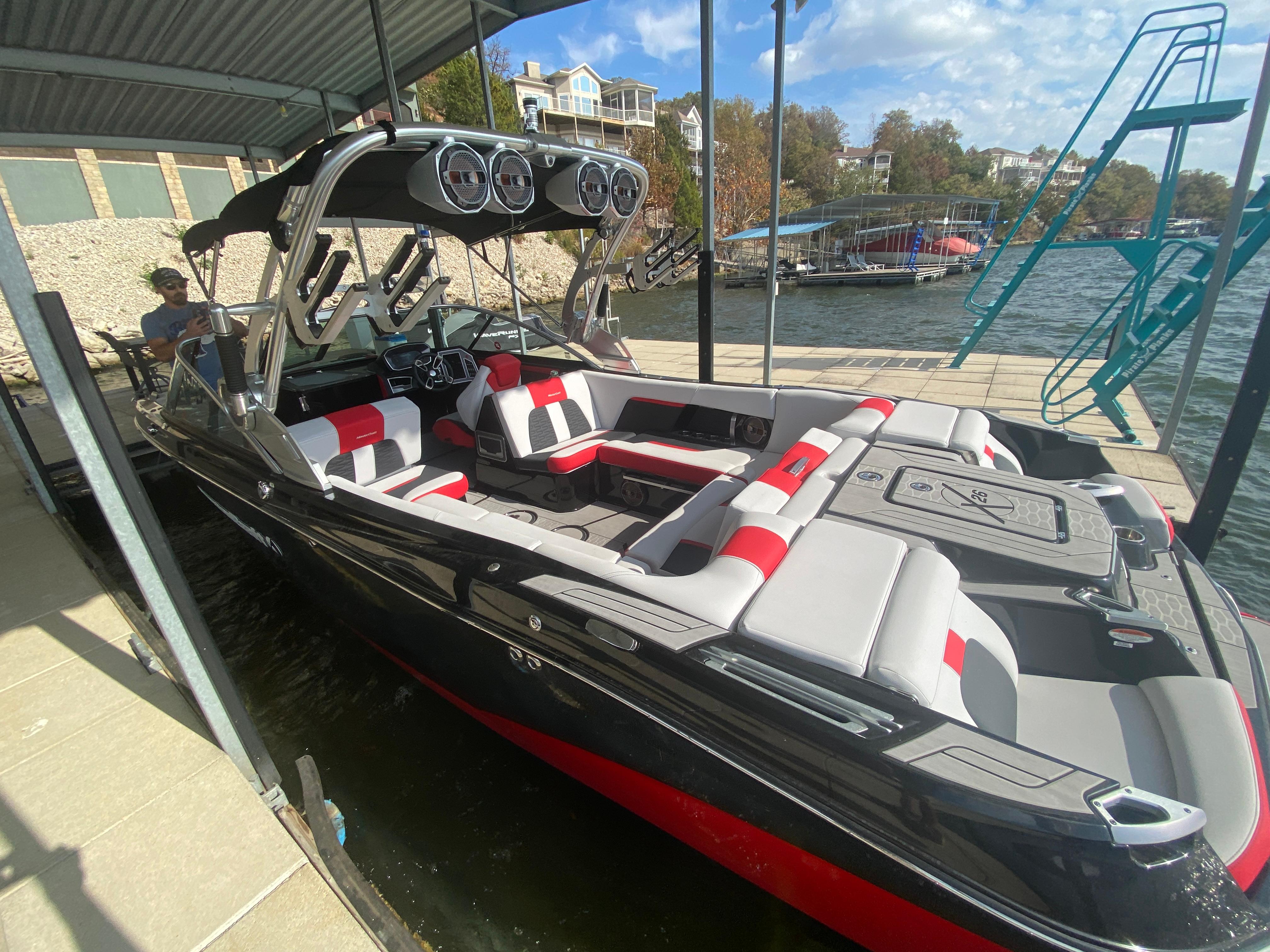 2021 MasterCraft X26 boat docked, featuring sleek design and spacious seating.