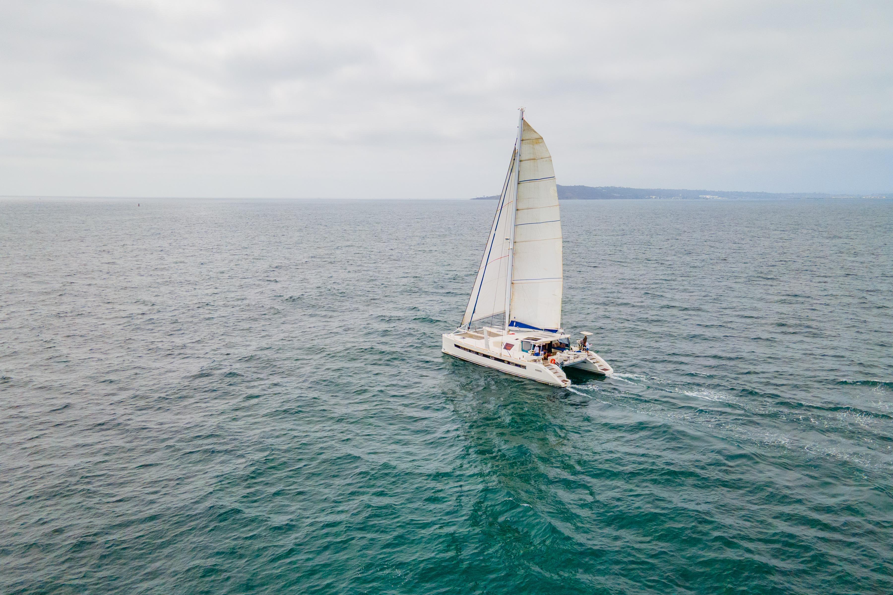 Sailing Catana 65 catamaran from 2009 on open sea under cloudy skies.