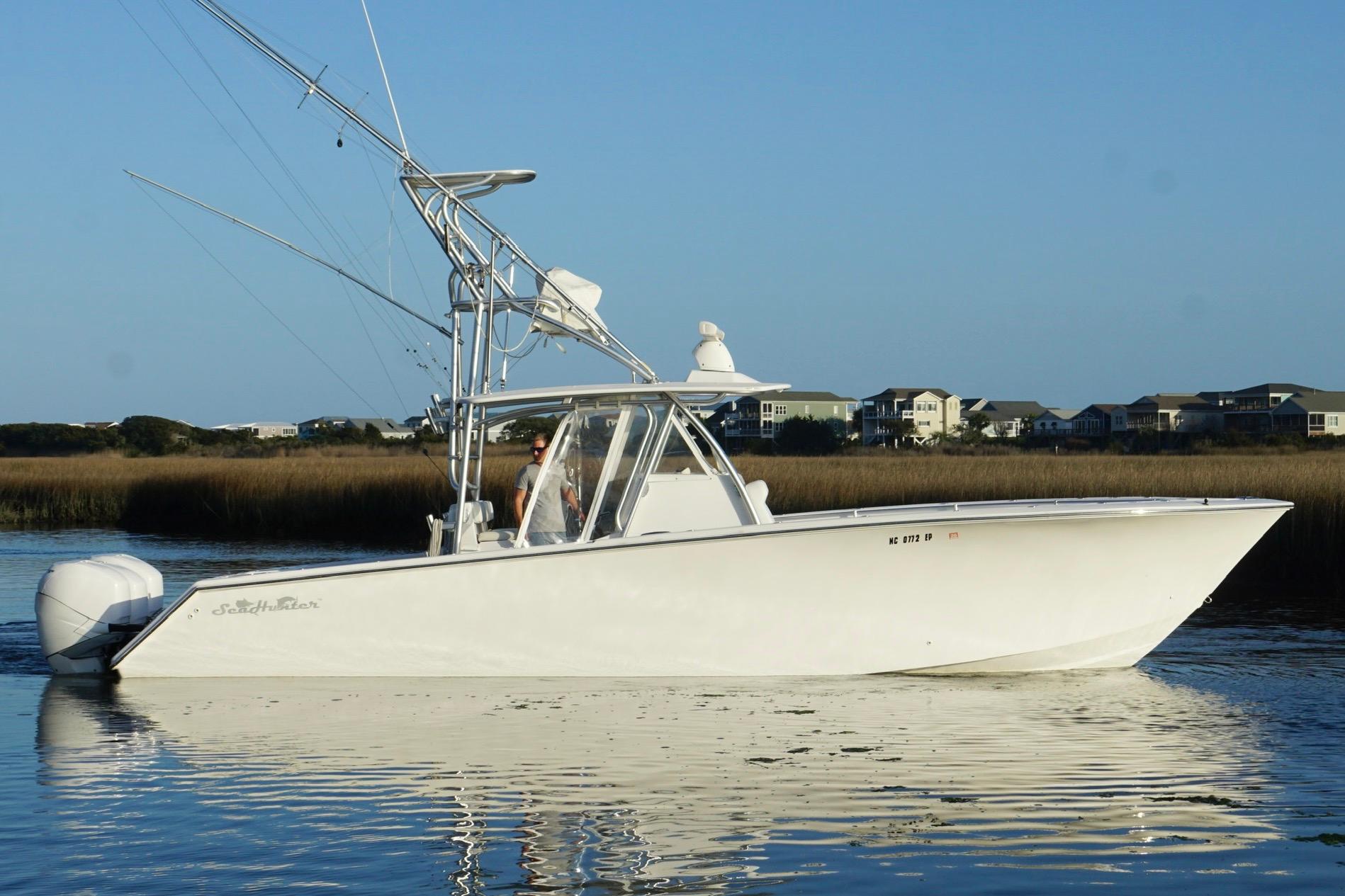 2017 SeaHunter 35 Tournament boat on calm water, coastal homes in background.