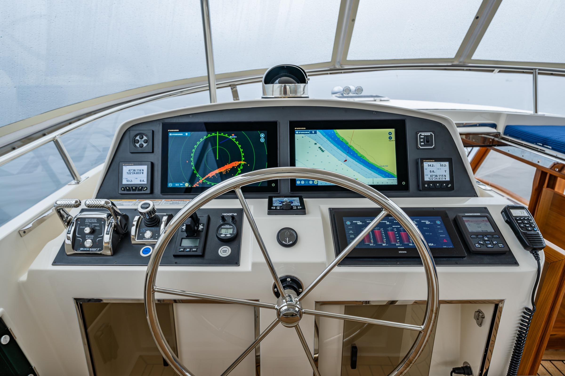 Pilothouse of 2026 Fleming 55, featuring advanced navigation systems and steering wheel.