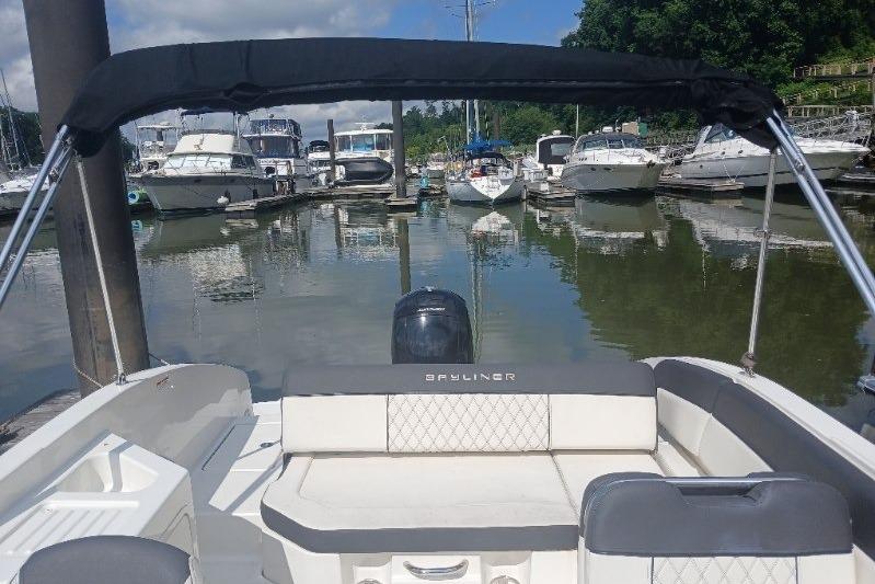 2023 Bayliner DX 2200 boat docked in a marina with other boats.