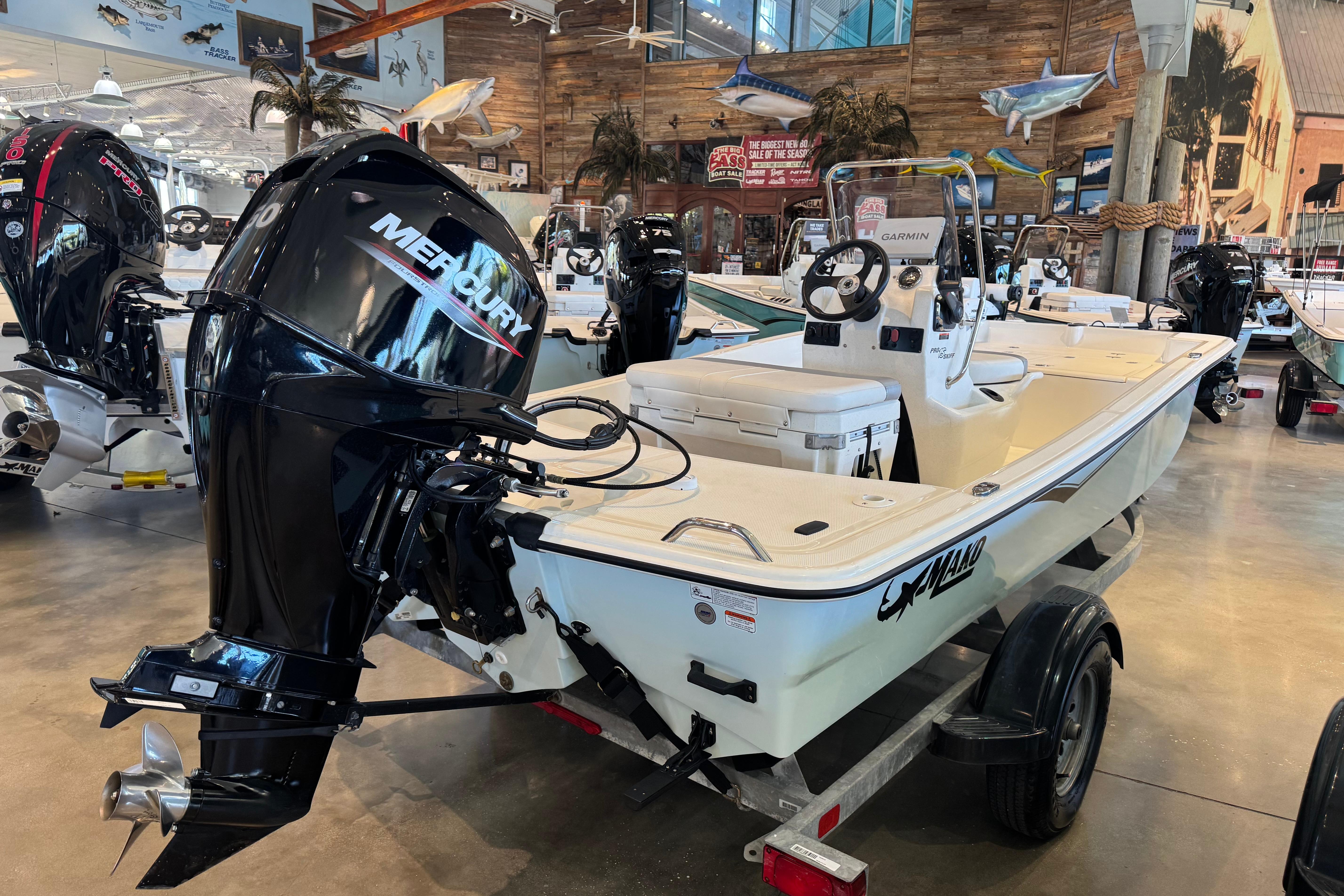 2025 Mako Pro Skiff 15 CC boat with Mercury engine in showroom display.