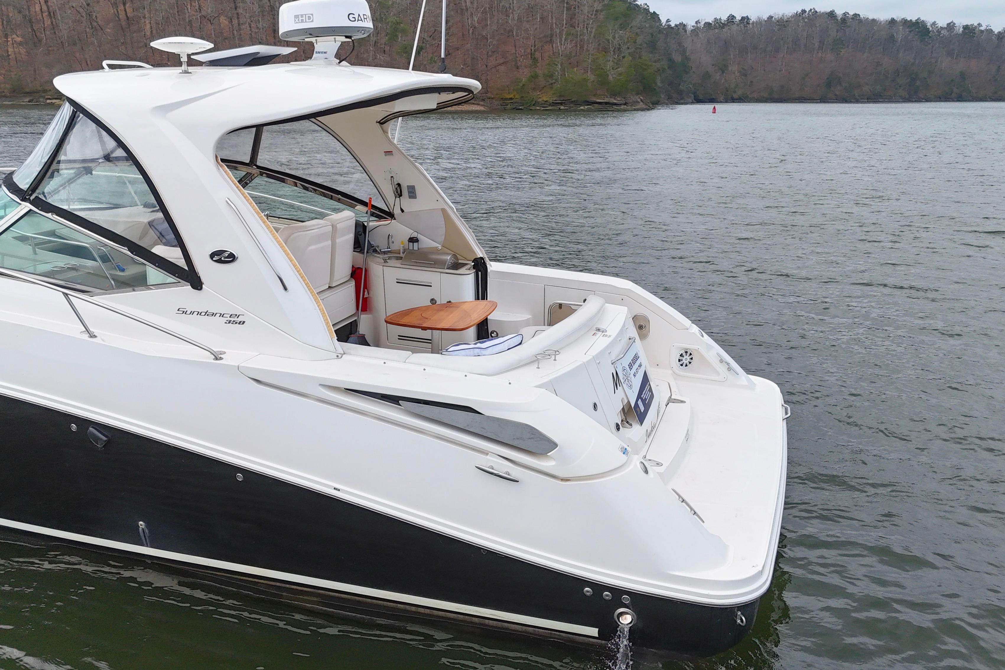 2009 Sea Ray Sundancer 350 yacht on a serene lake with wooded shoreline.