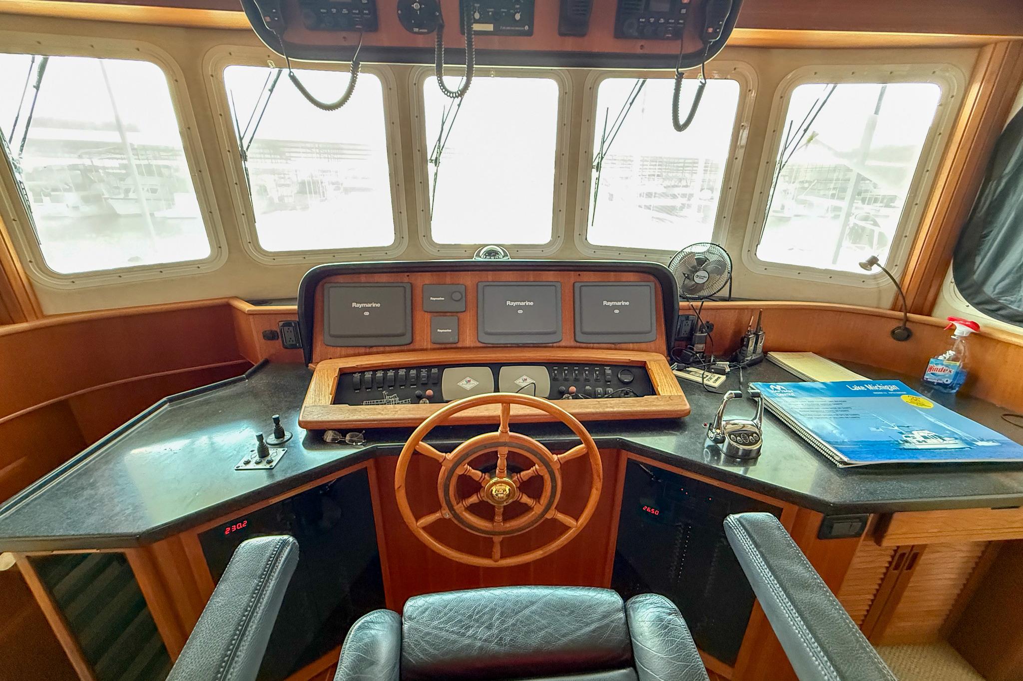 Pilot house of a 2007 Nordic Tug 54 with navigation equipment and steering wheel.