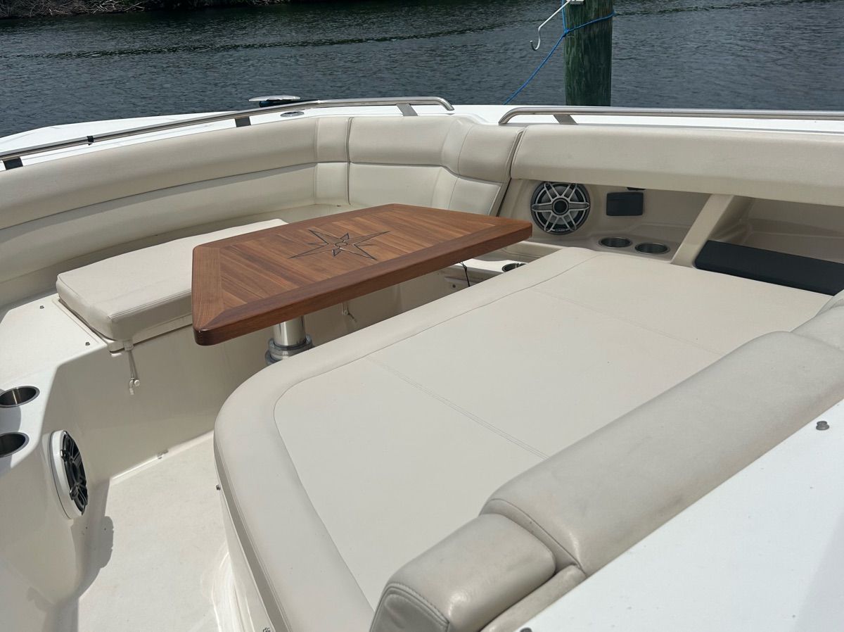 The 2021 Boston Whaler 350 Realm features a luxurious seating area with a wooden table.