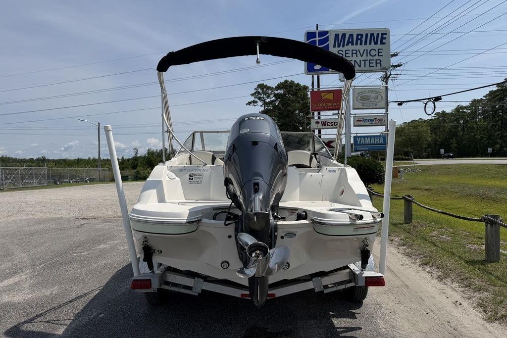 2019 Stingray 201 DS boat at marine service center, rear view with outboard motor.