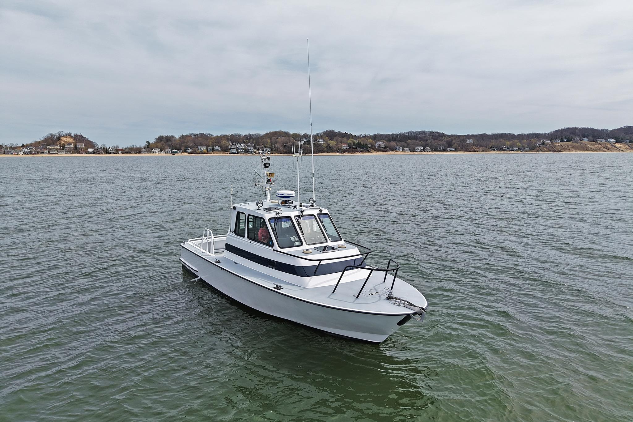 1990 Boston Whaler 36 Defiance boat on calm water with distant shoreline.