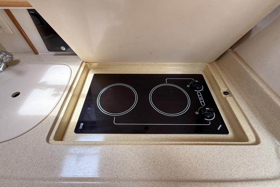 1999 Sea Ray 290 Sundancer kitchen with electric stovetop and sink.