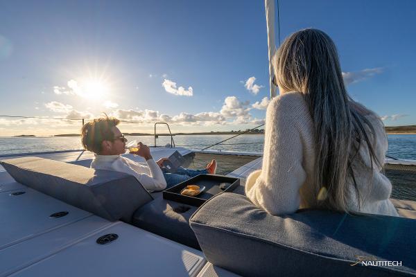 Couple relaxing on Nautitech 48 Open yacht, enjoying sunset on the water, 2025 model.